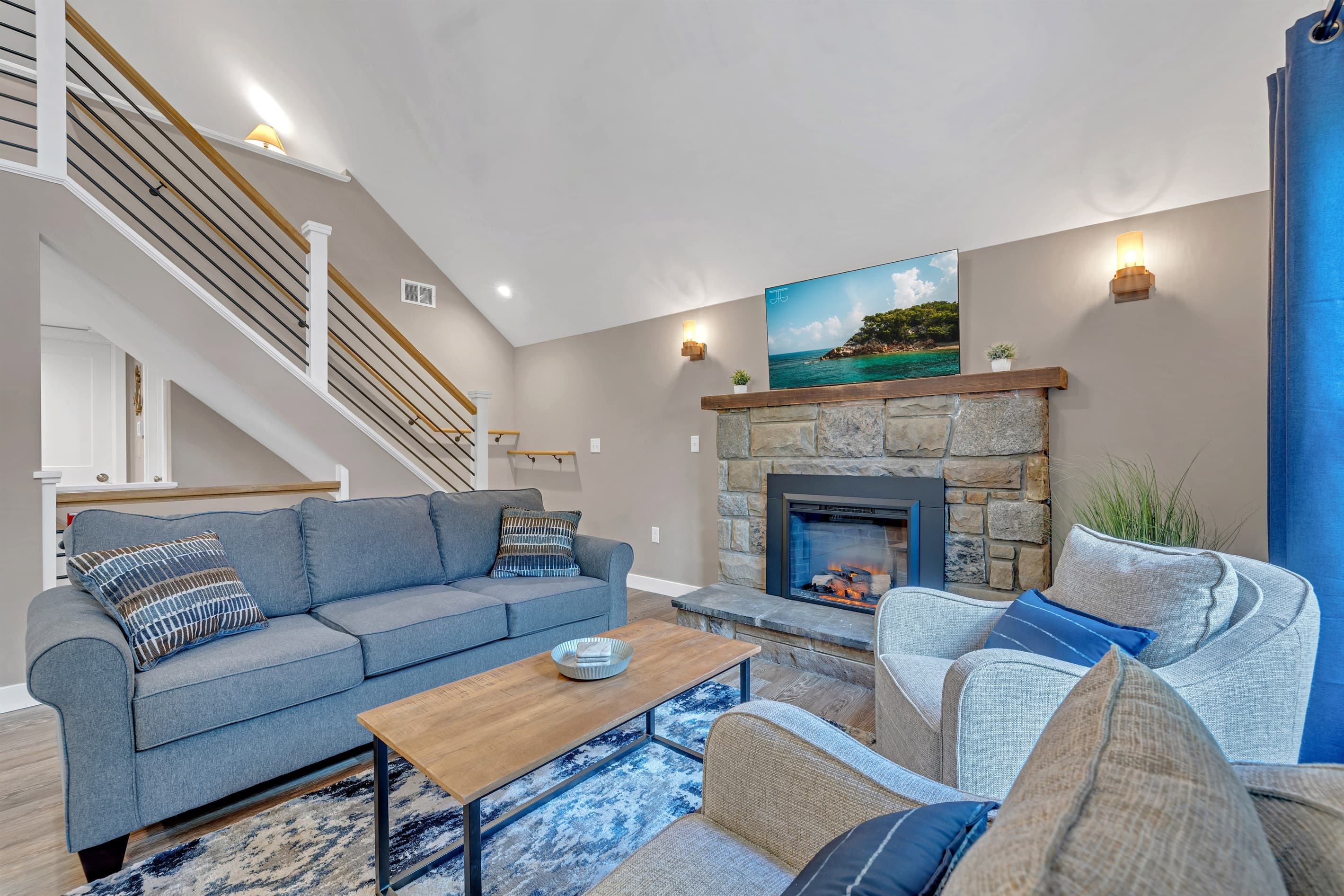 Living room with comfortable furniture and TV with electric fireplace