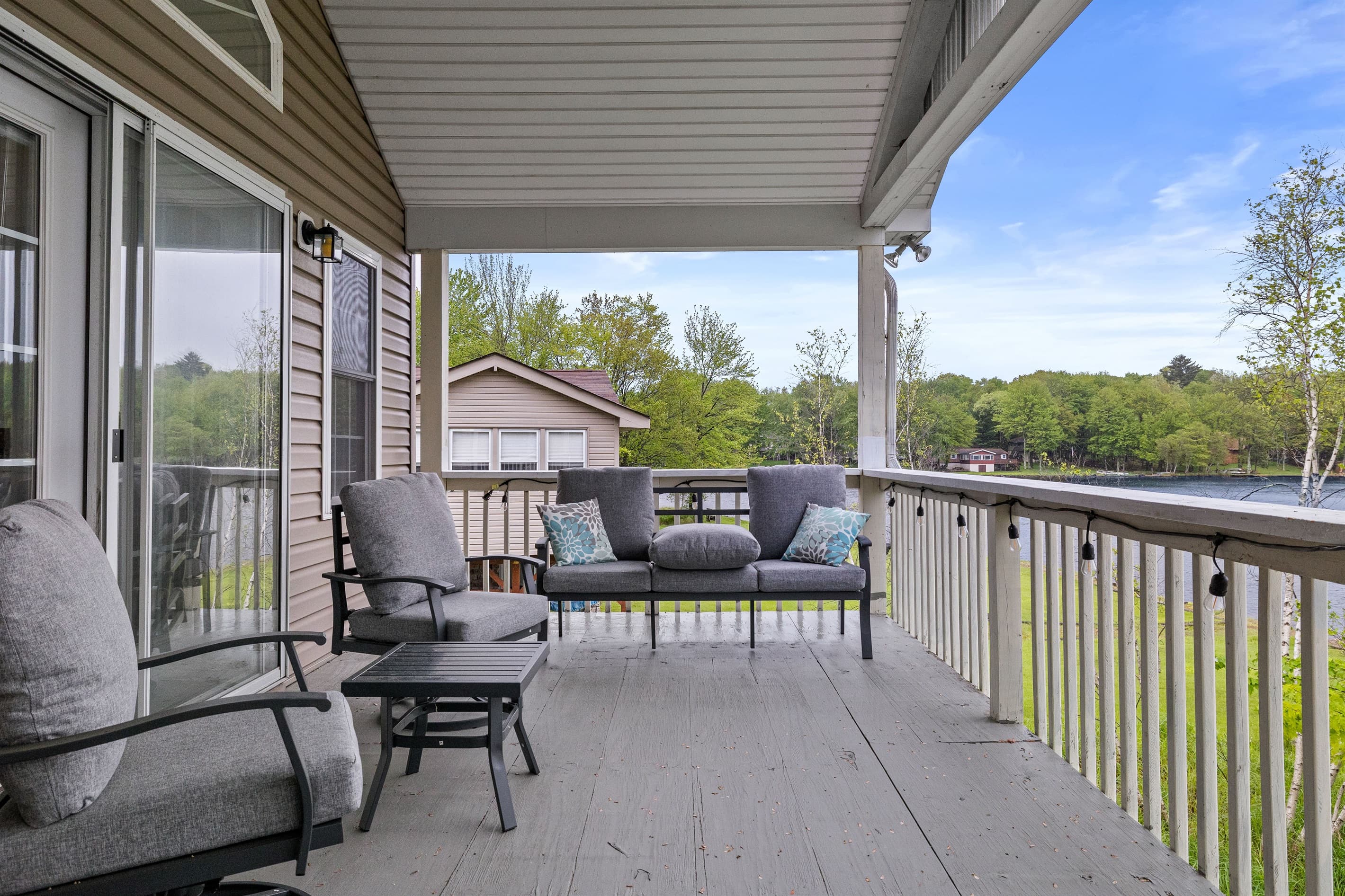 Covered upper-level deck with a seating area and outdoor dining table—ideal for meals with a view.