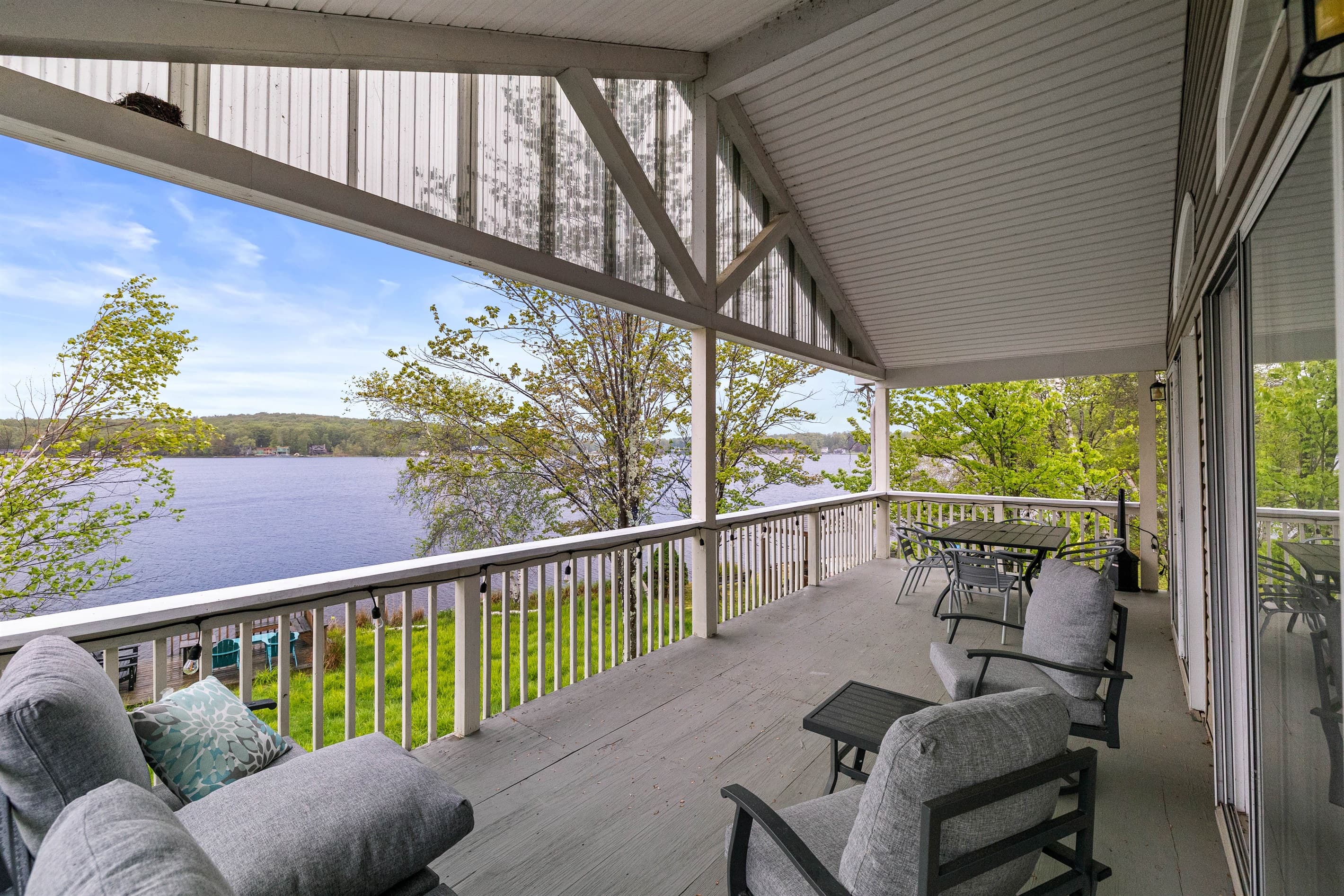 Covered upper-level deck with a seating area and outdoor dining table—ideal for meals with a view.