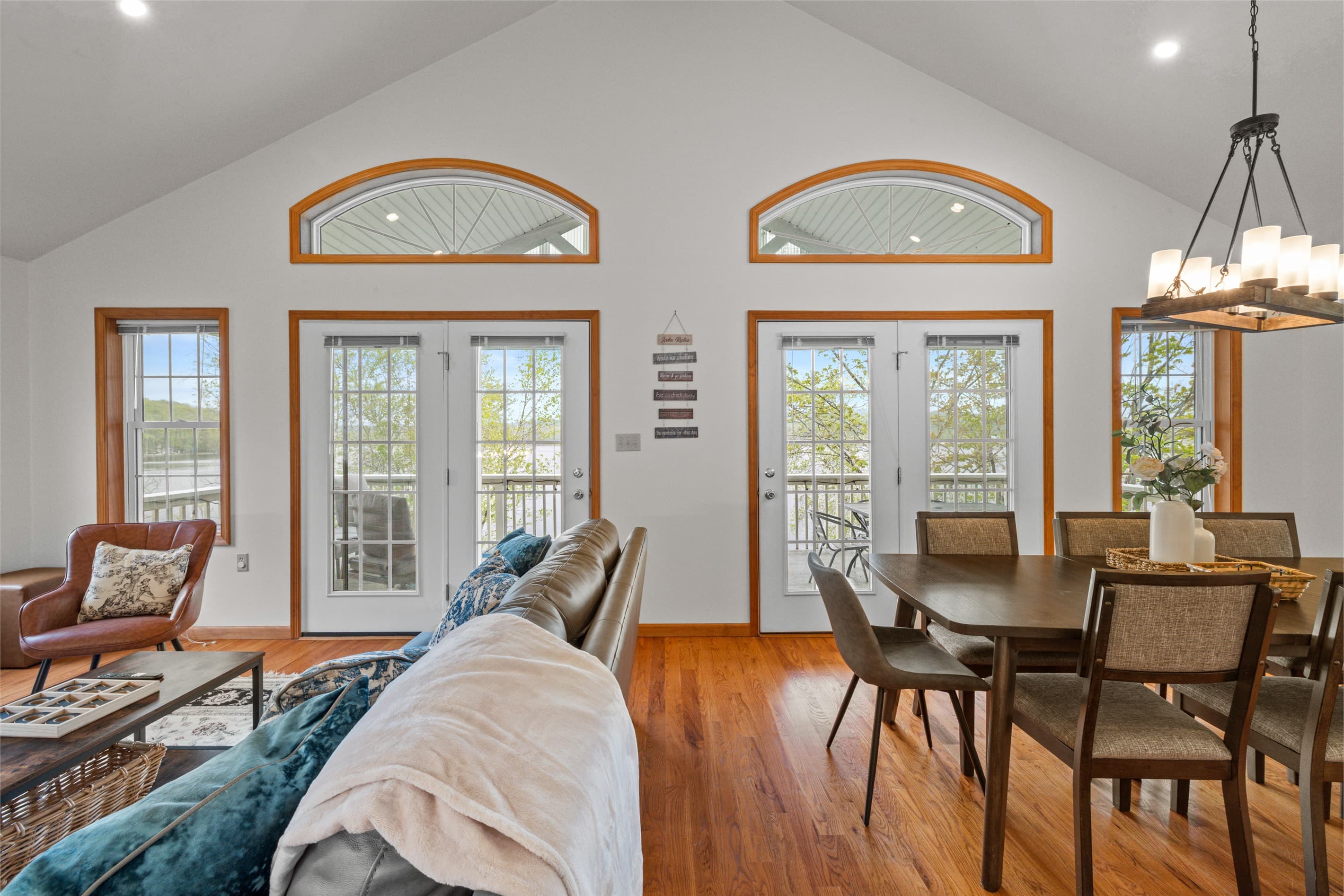 Living room with Smart TV to stream favorite shows, comfortable sofa and chairs. Exit to balcony with lakeview