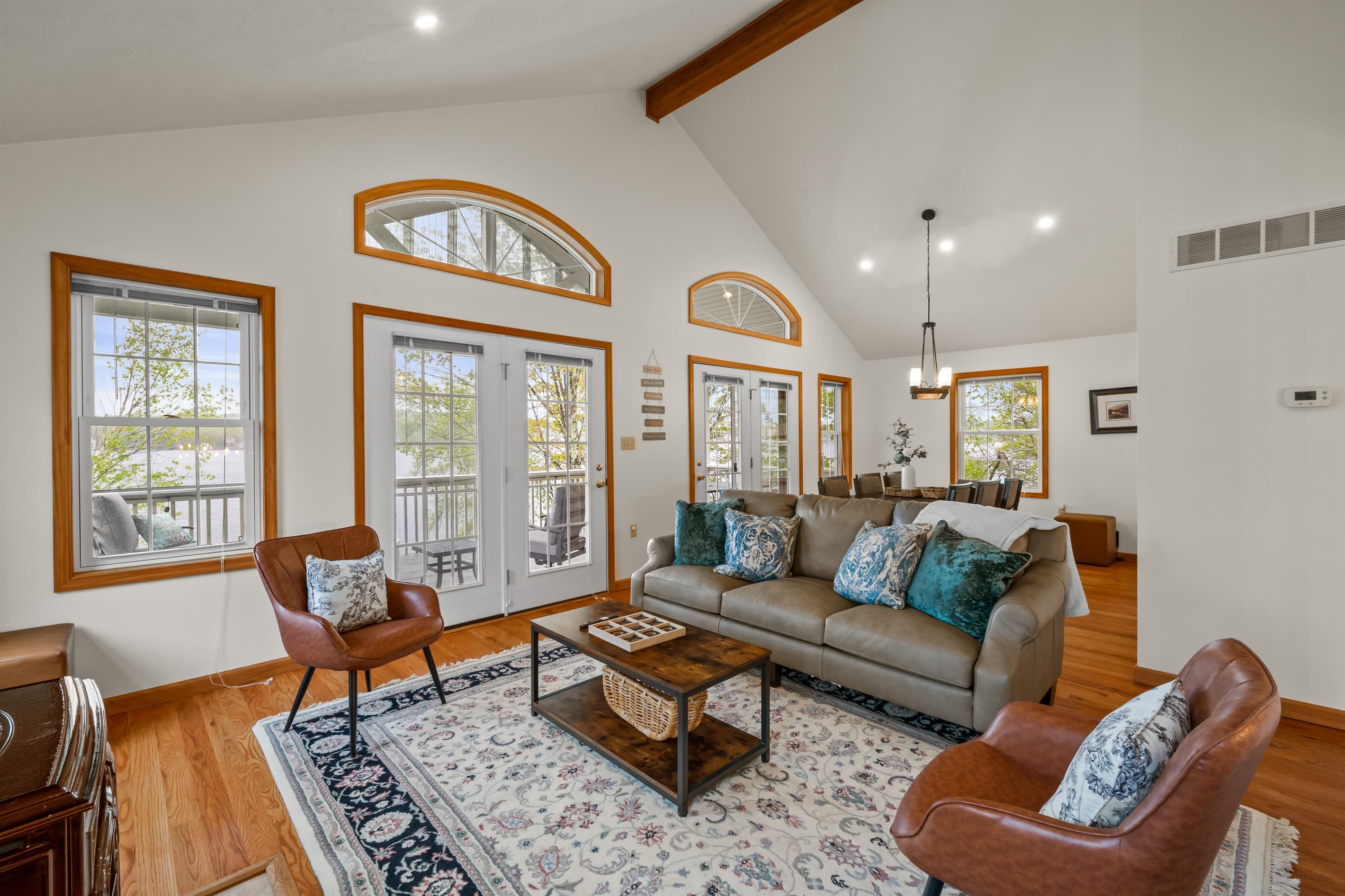 Living room with Smart TV to stream favorite shows, comfortable sofa and chairs. Exit to balcony with lakeview