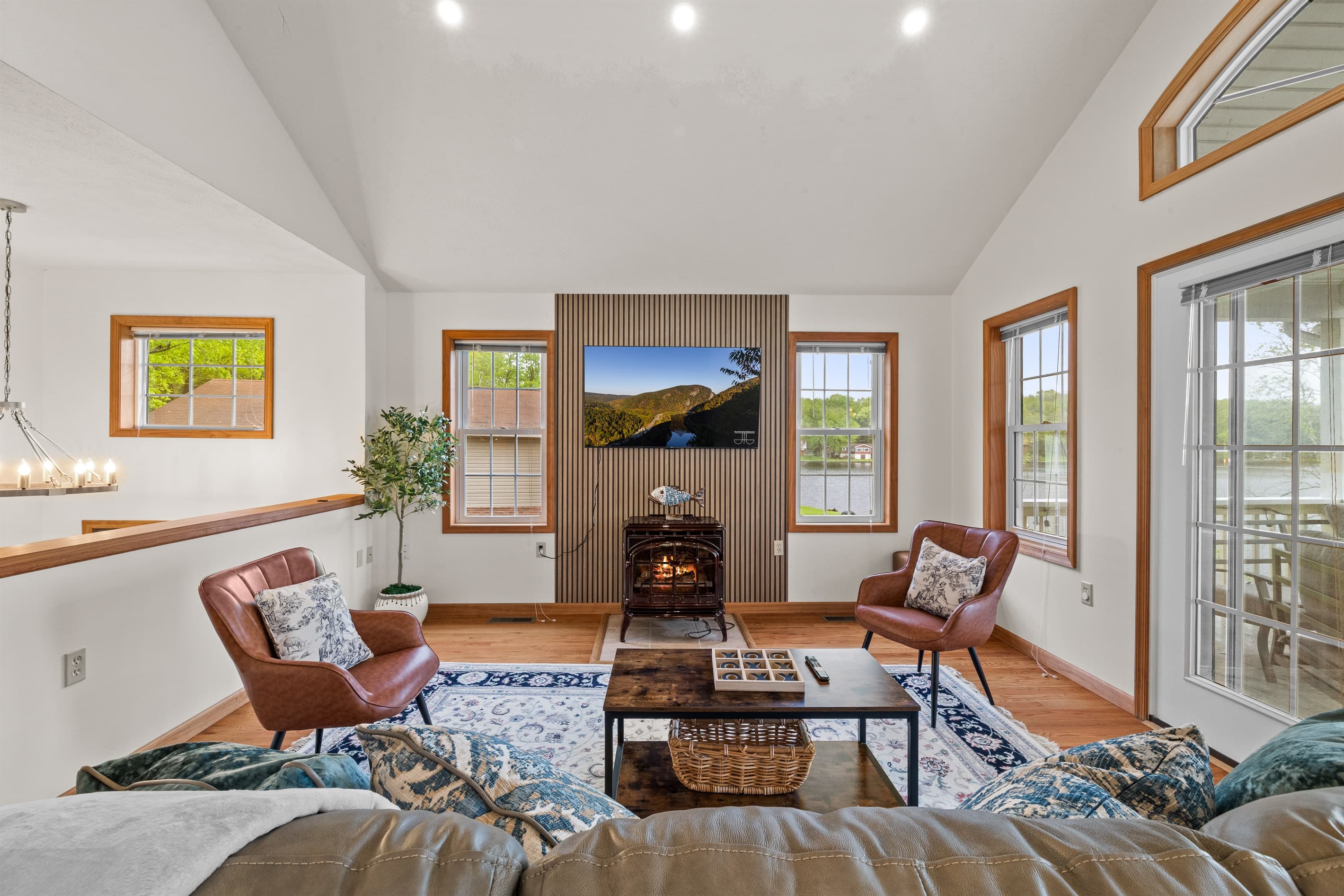 Living room with Smart TV to stream favorite shows, comfortable sofa and chairs. Exit to balcony with lakeview