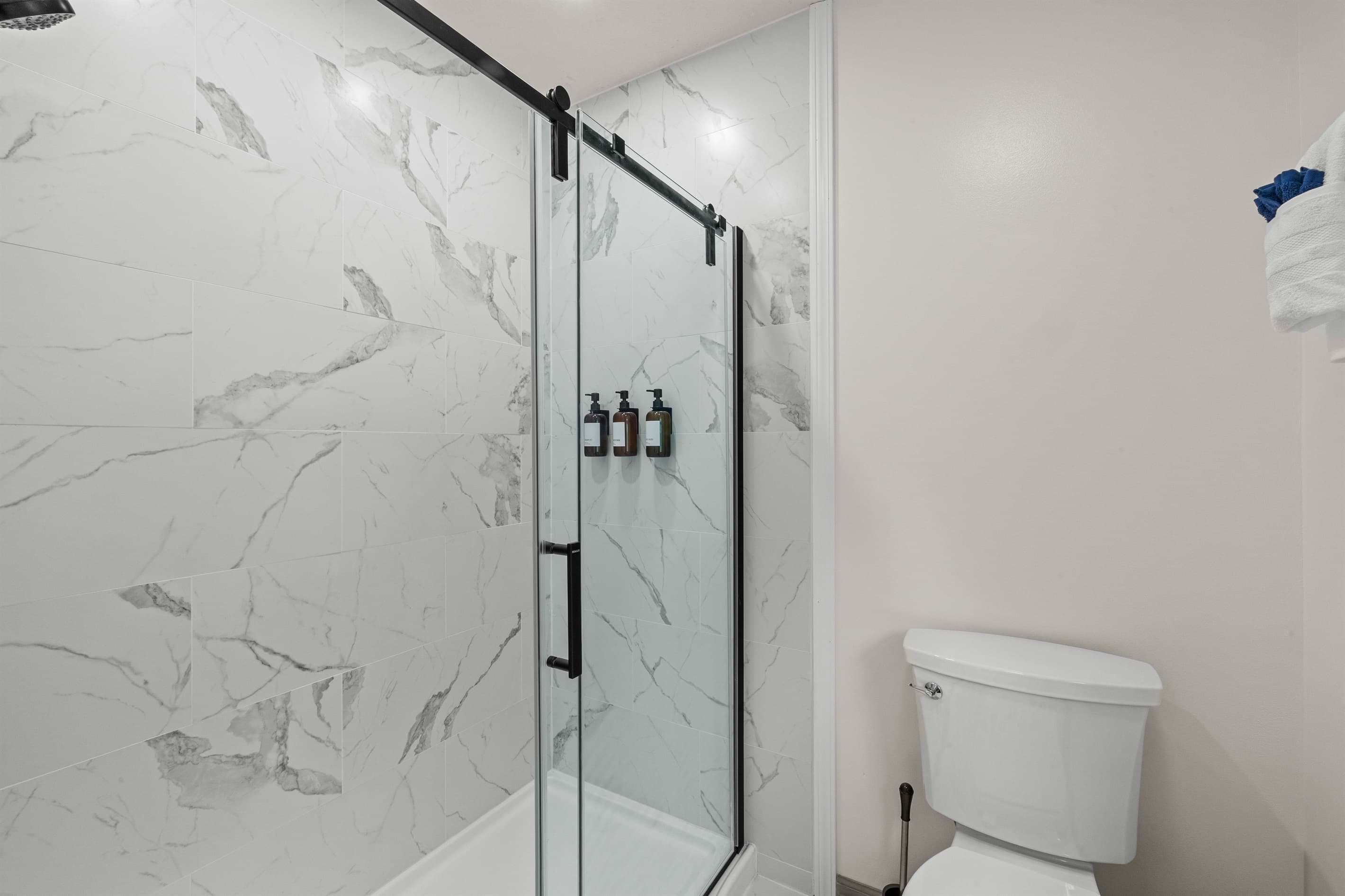 Ensuite bathroom featuring a sink, mirror, toilet, and walk-in shower for convenience and comfort.