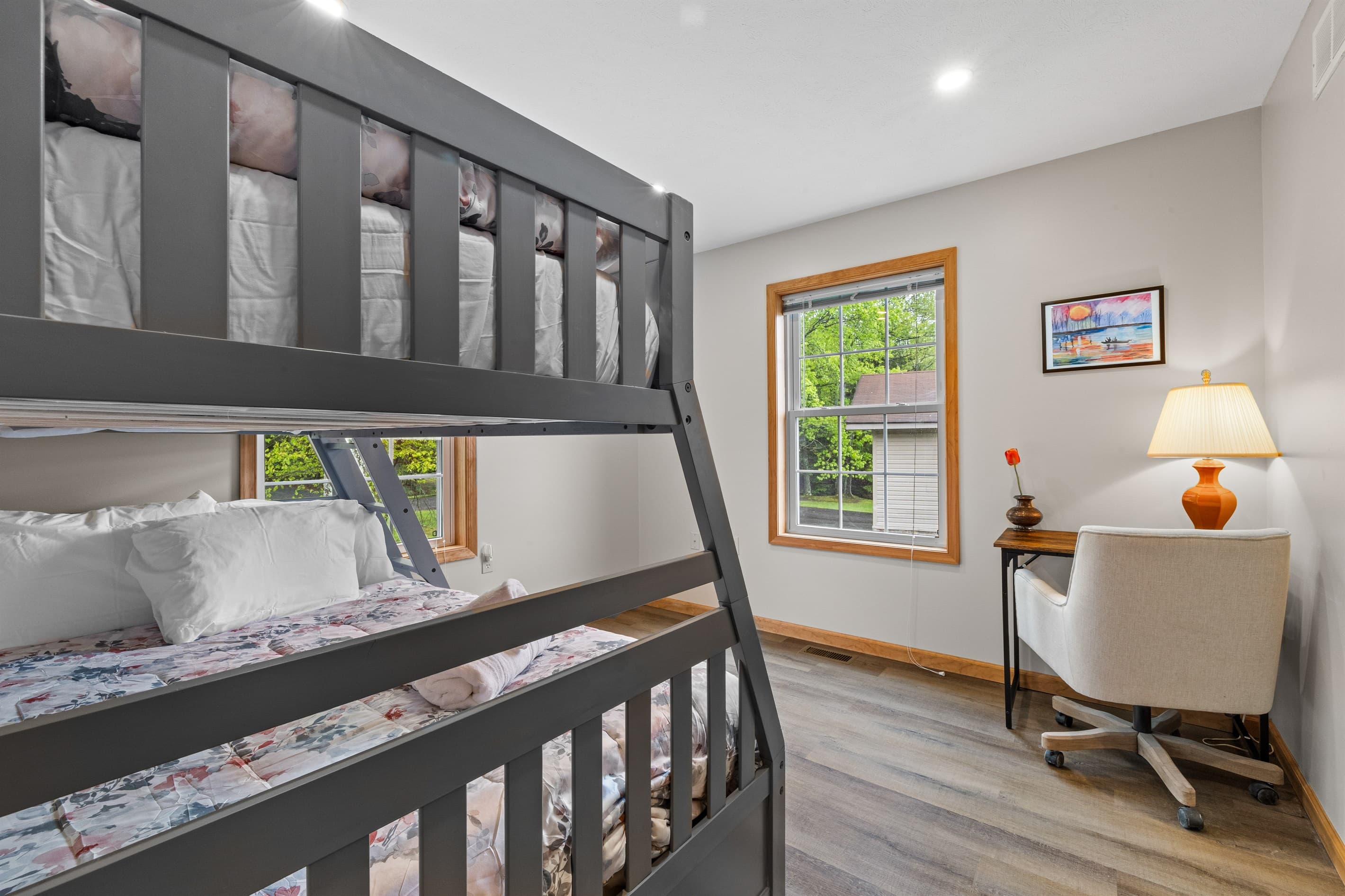 Cozy bedroom with a twin-over-full bunk bed and a small workspace, perfect for kids or remote work.