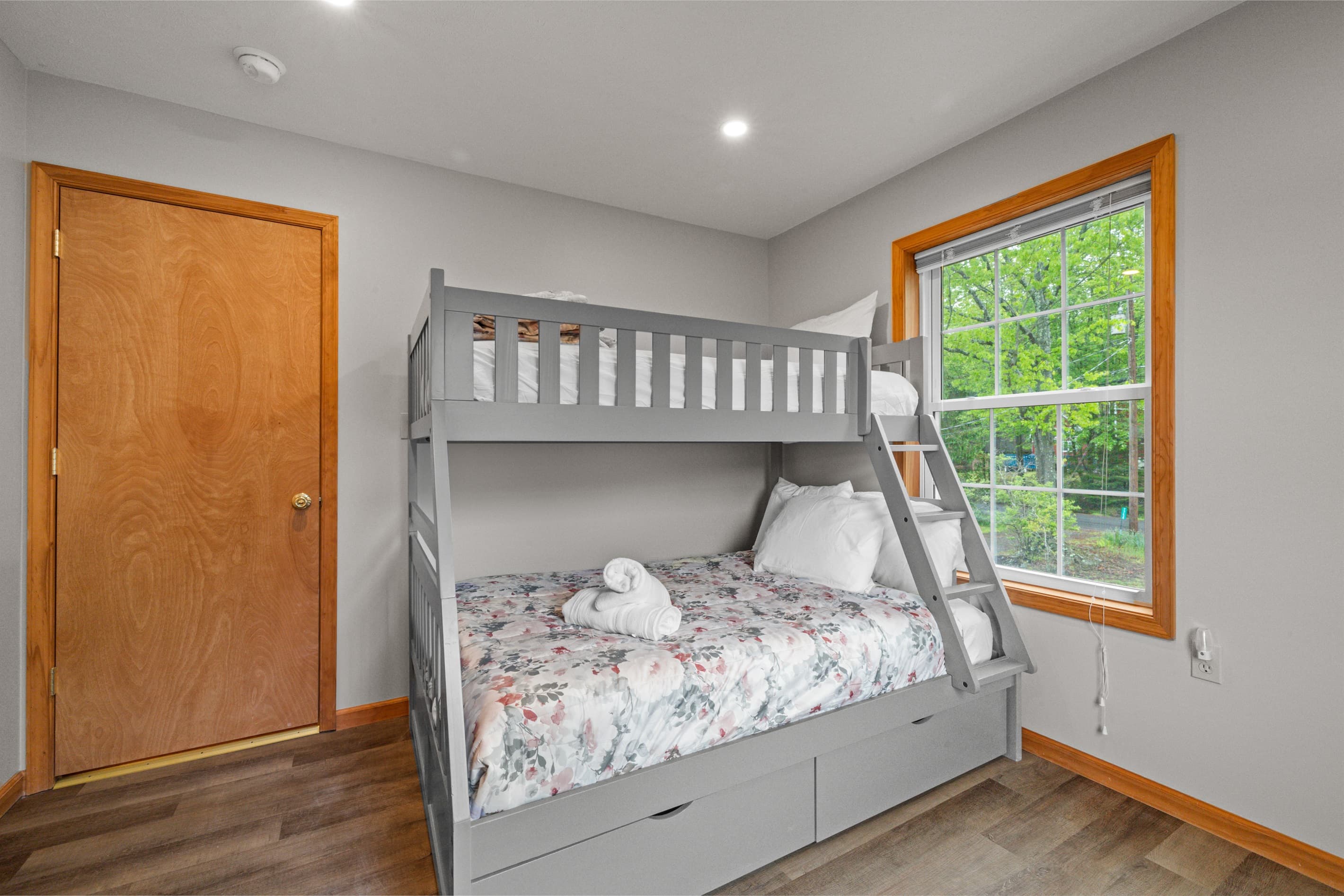 Cozy bedroom with a twin-over-full bunk bed and a small workspace, perfect for kids or remote work.