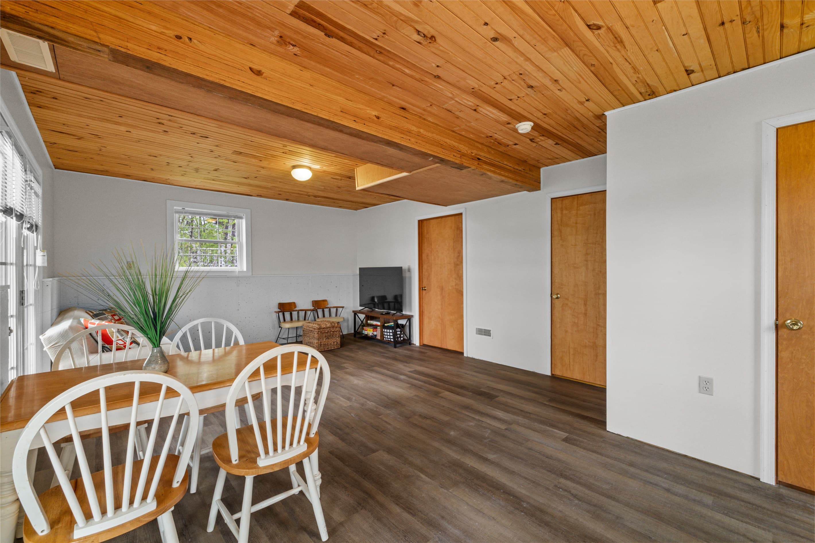 Bonus room offers extra space to spread out, featuring a full-size bed, a cozy TV sofa, and a small dining table—perfect for games, casual meals, or relaxing with a movie.