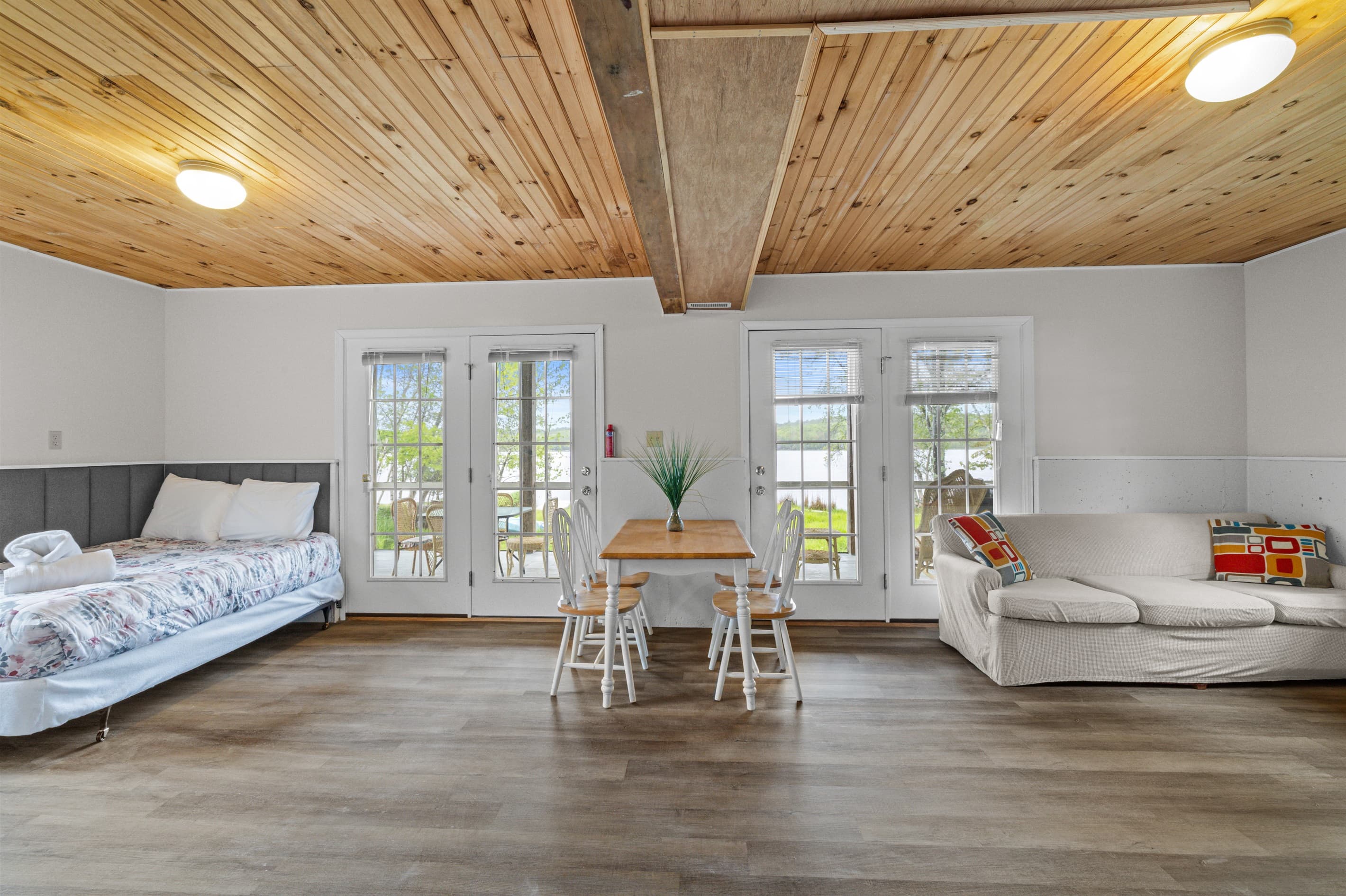 Bonus room offers extra space to spread out, featuring a full-size bed, a cozy TV sofa, and a small dining table—perfect for games, casual meals, or relaxing with a movie.