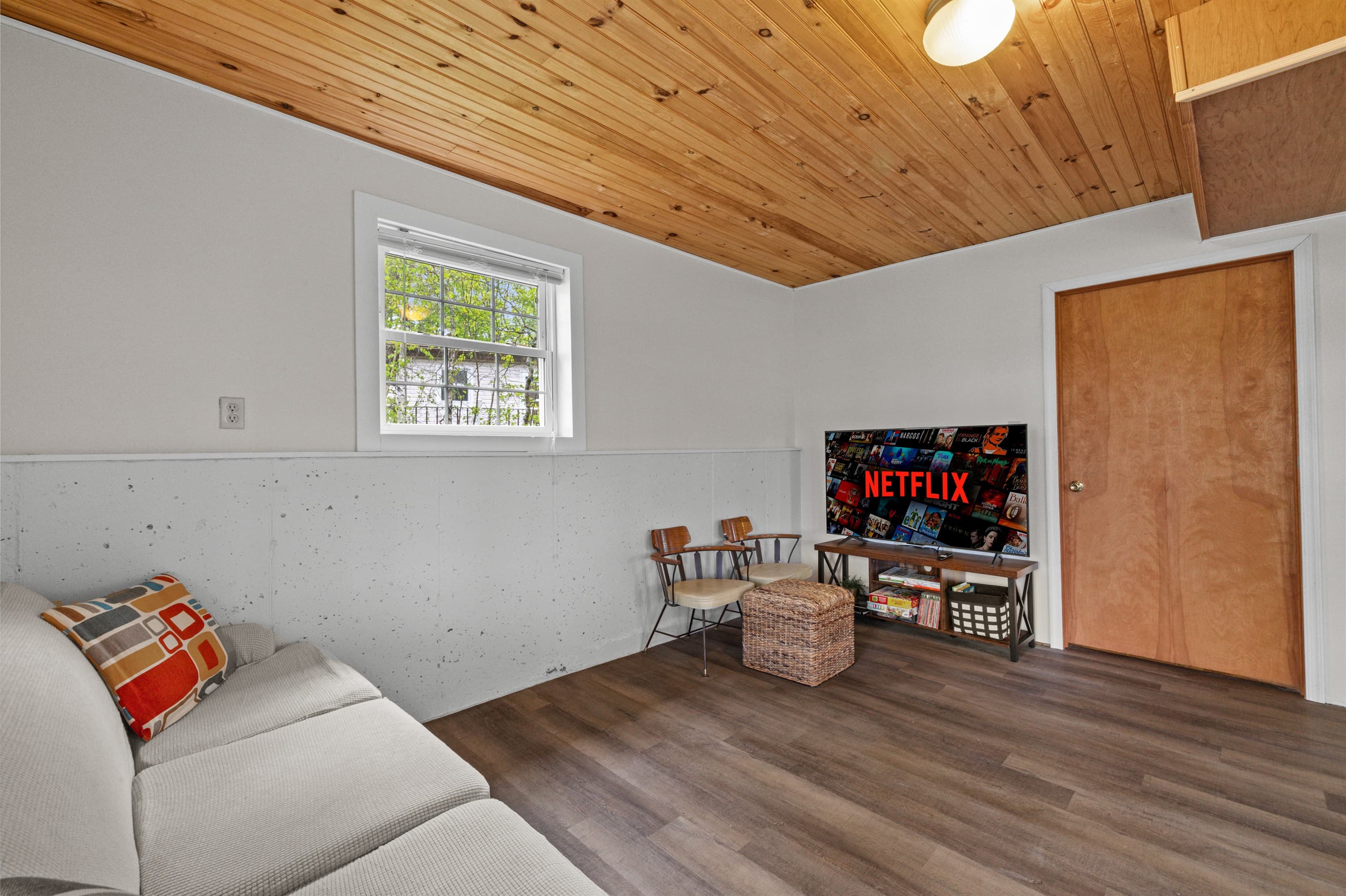 Bonus room offers extra space to spread out, featuring a full-size bed, a cozy TV sofa, and a small dining table—perfect for games, casual meals, or relaxing with a movie.
