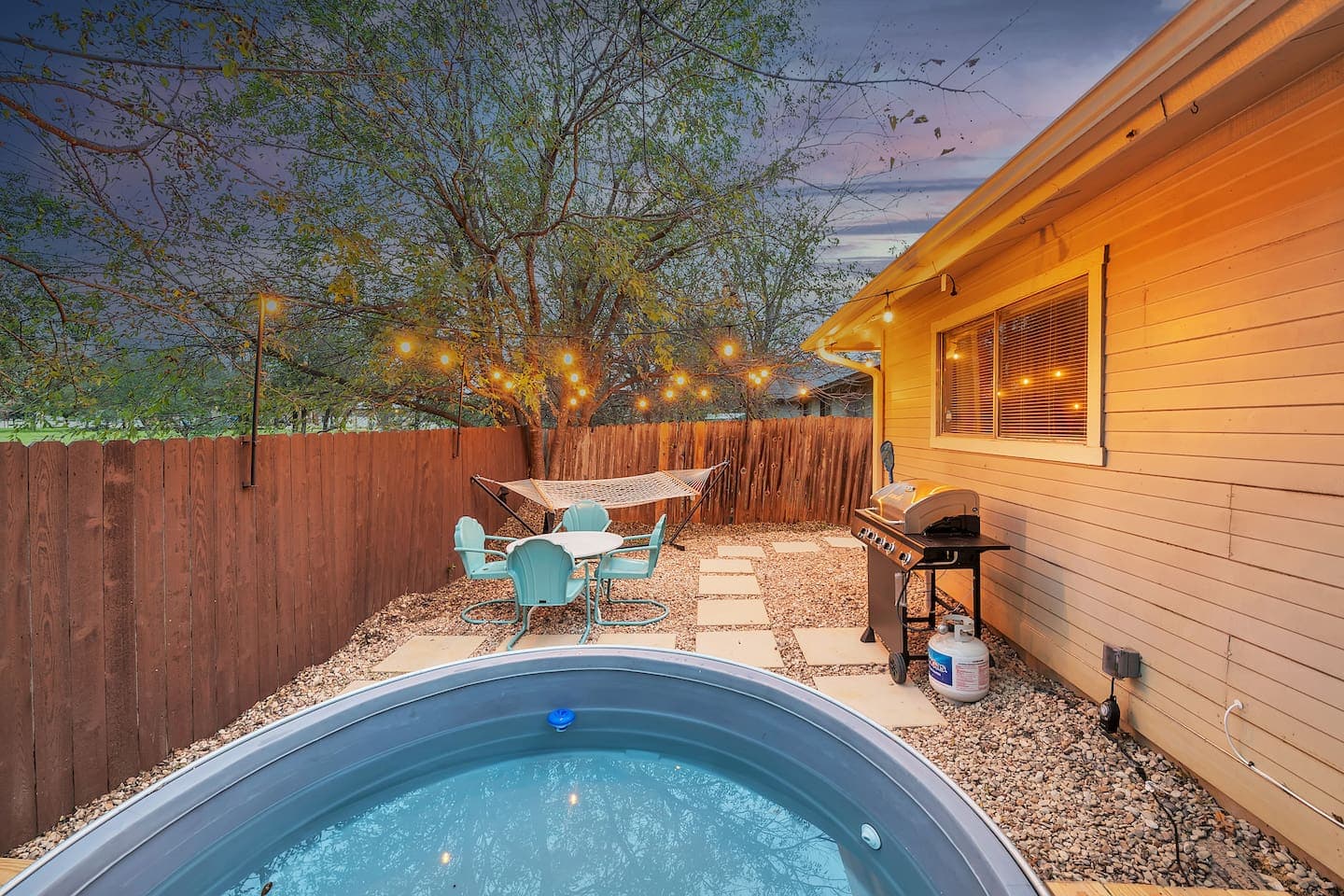 Rustic relaxation under the stars: Unwind in our cozy backyard oasis, complete with a charming cowboy pool, deck, and lights.