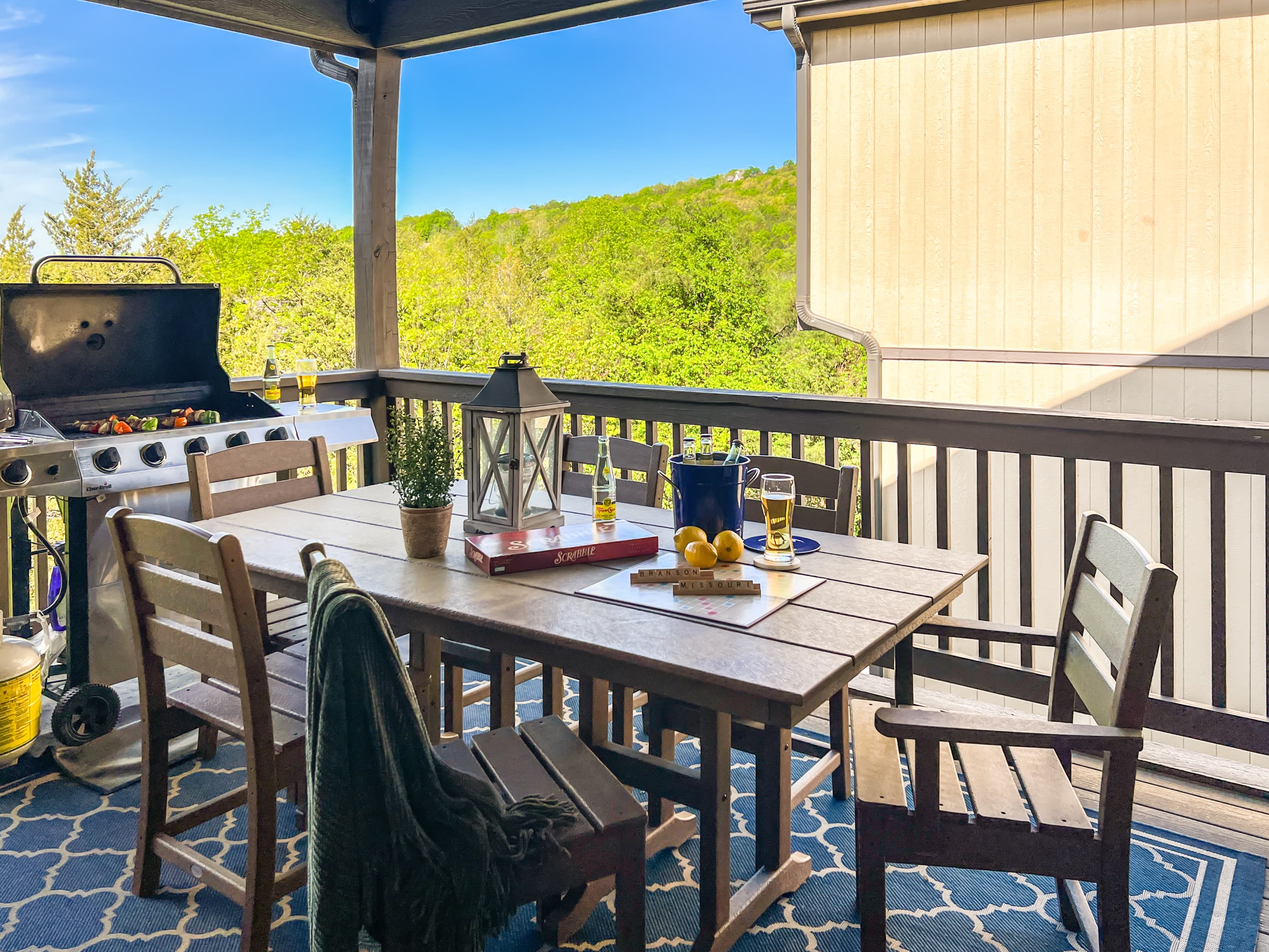 Step from the living room onto the covered mountain-view deck with a 6-seat table and grill