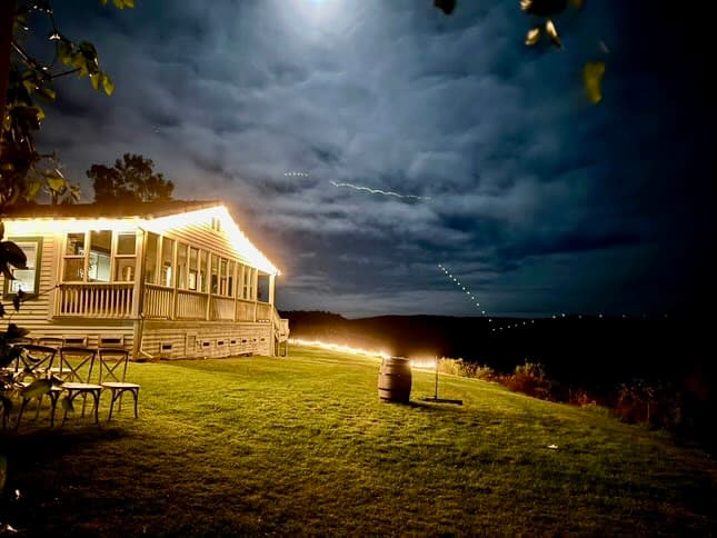 Bistro lights illuminate the grounds at night.
