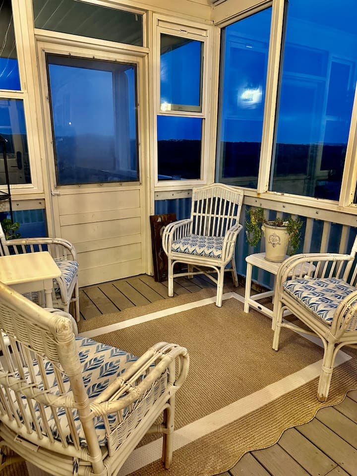 The enclosed sun porch is cozy any time of day or evening.