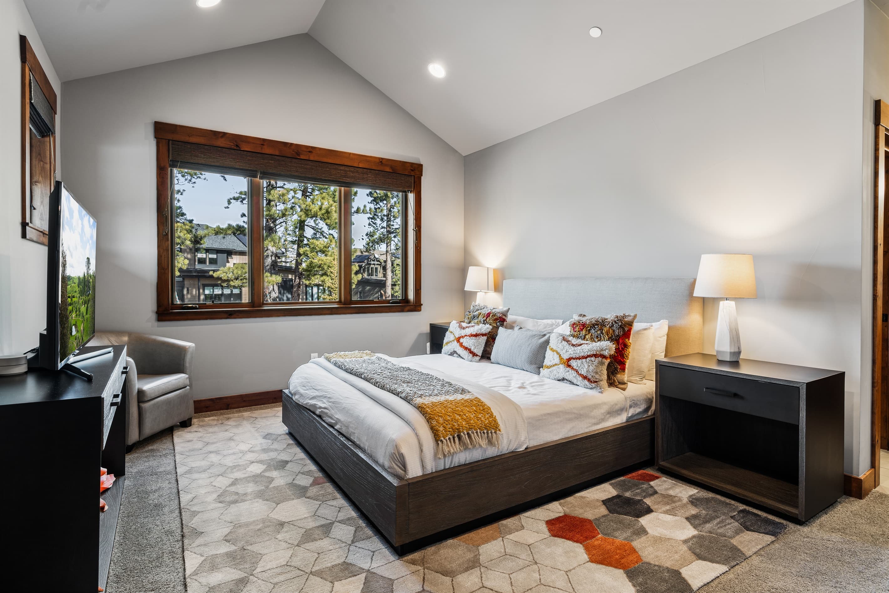 This luxurious upstairs master suite features a plush king bed, a 49" Smart TV, and an en-suite bathroom, offering a serene retreat perfect for unwinding after a day of Tahoe adventures.