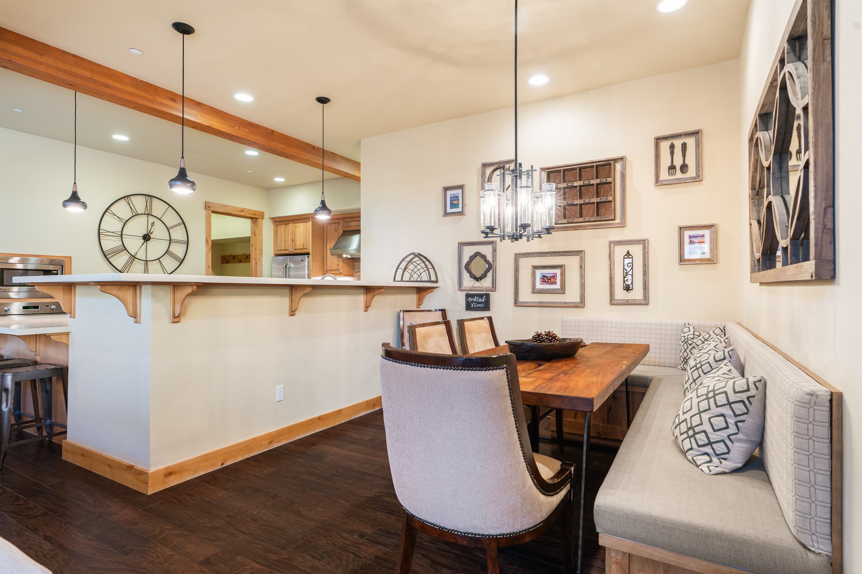 The dining area features a table with three chairs and a cozy breakfast-nook bench, all seamlessly connected to the kitchen and living room for an open, inviting feel.