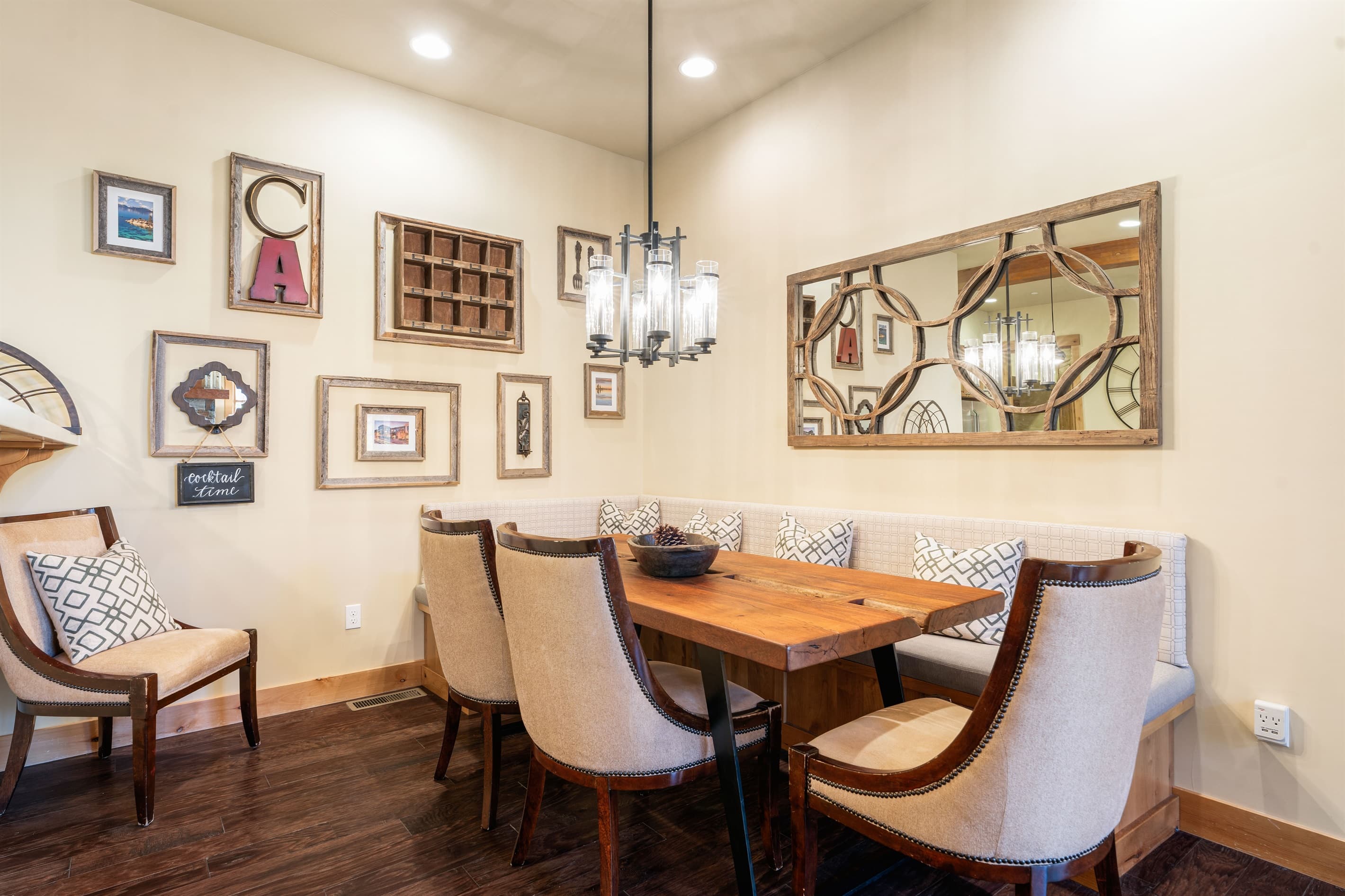 The dining area features a table with three chairs and a cozy breakfast-nook bench, all seamlessly connected to the kitchen and living room for an open, inviting feel.