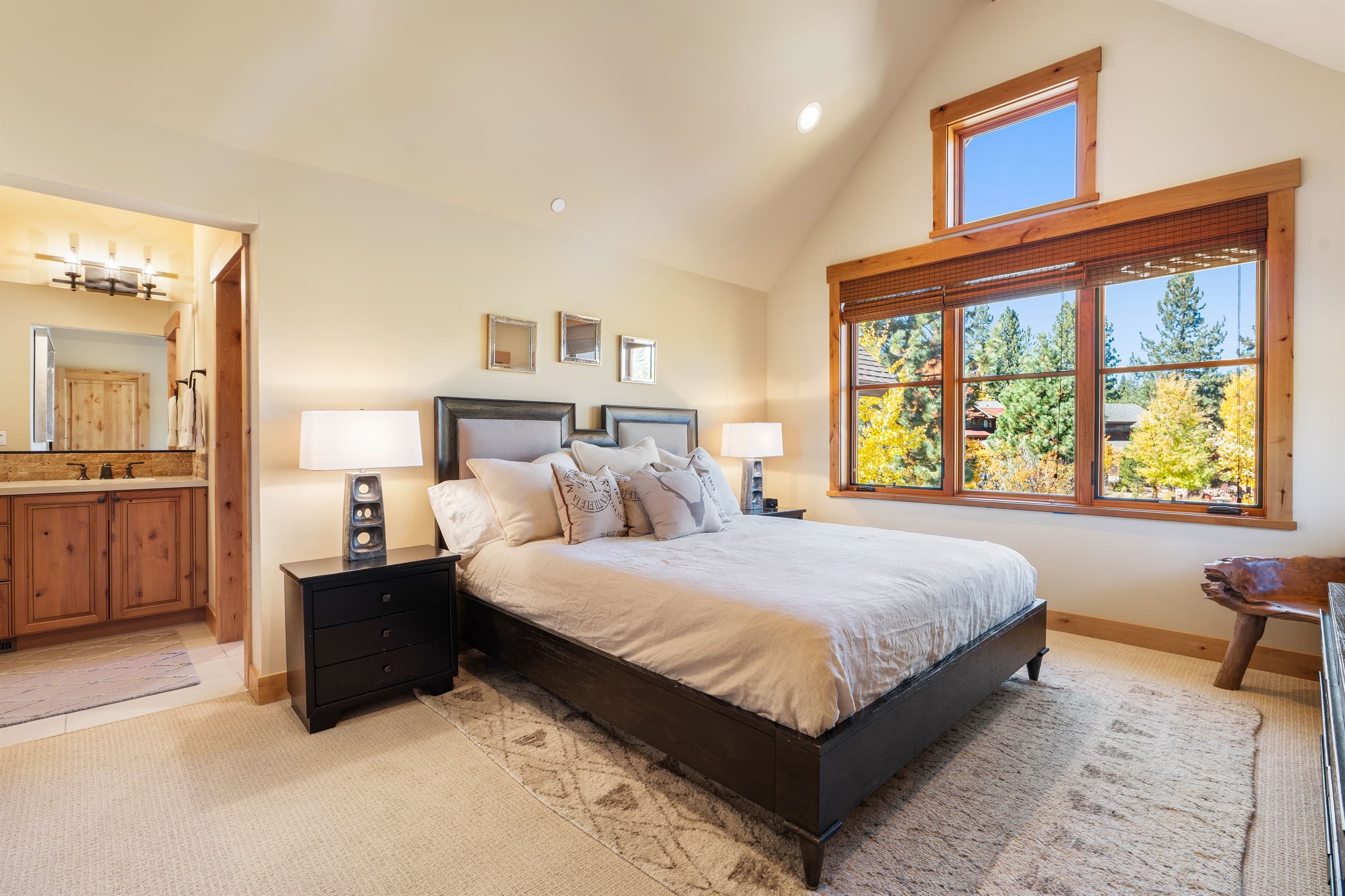 This upstairs bedroom features a plush king bed, an en-suite bathroom, and a TV for added comfort and convenience.