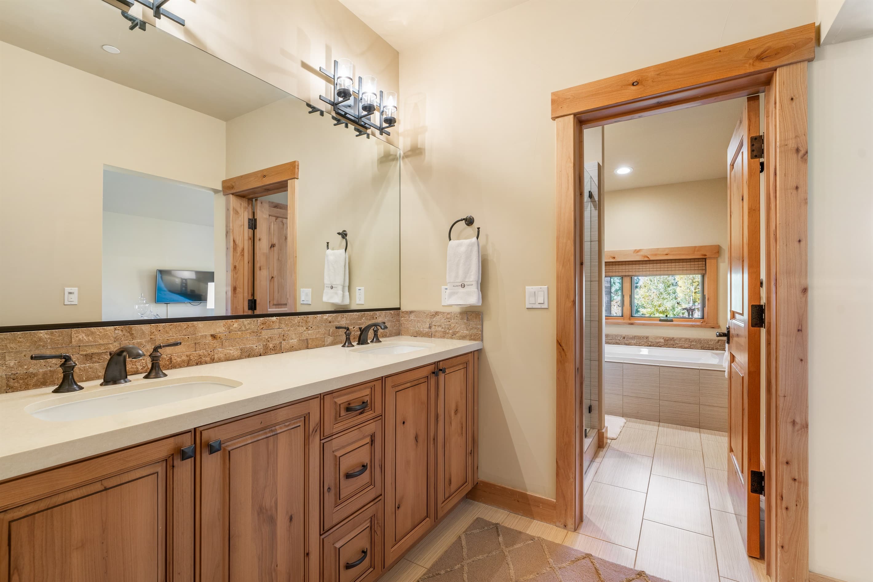 The upstairs bathroom offers a soaking tub, walk-in closet, dual vanities, and a spacious walk-in shower, creating a serene space designed for relaxation. Stocked with towels, hand soap, shampoo, conditioner, body wash and toilet paper.