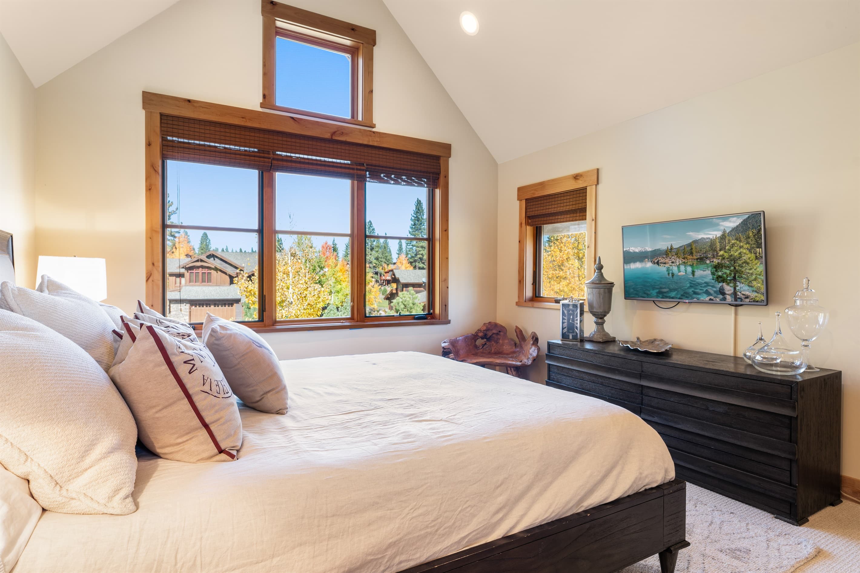 This upstairs bedroom features a plush king bed, an en-suite bathroom, and a TV for added comfort and convenience.