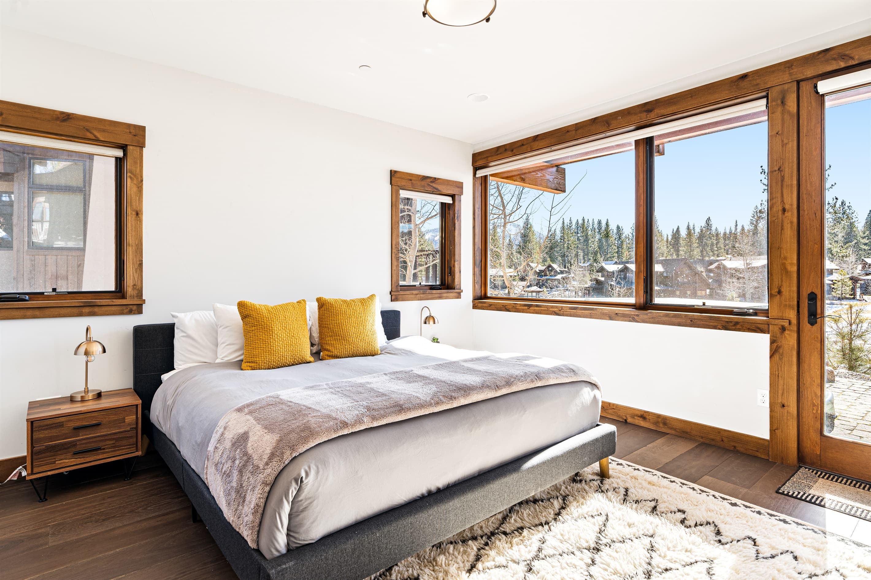 This downstairs bedroom features a plush king bed, offering ultimate comfort. Enjoy stunning views right from your room and step outside to the lower patio, where a private hot tub awaits for a relaxing soak amidst the beauty of Schaffer's Mill.