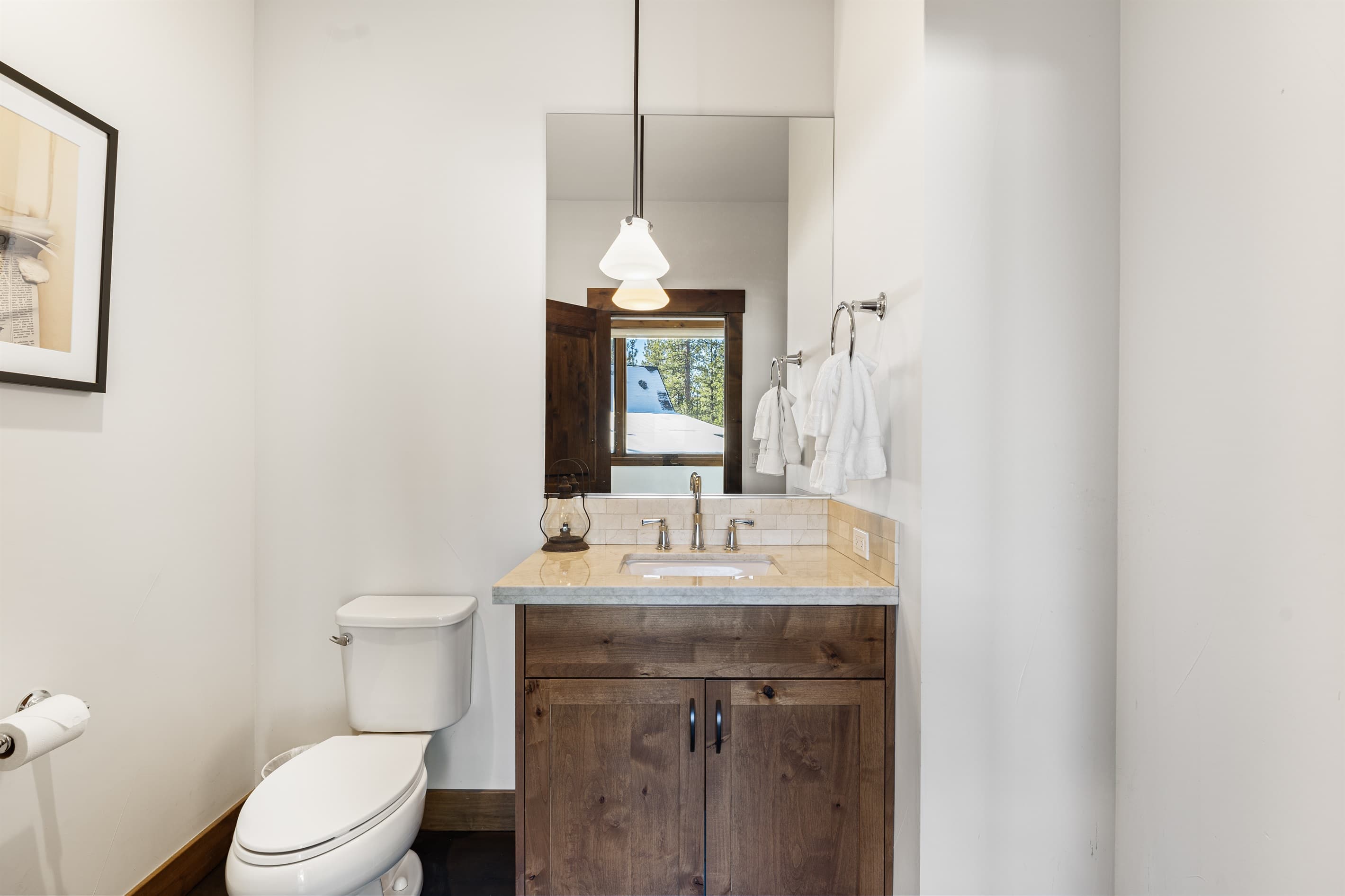 This half bathroom features a single vanity and is thoughtfully stocked with ample hand soap and toilet paper for a comfortable stay.