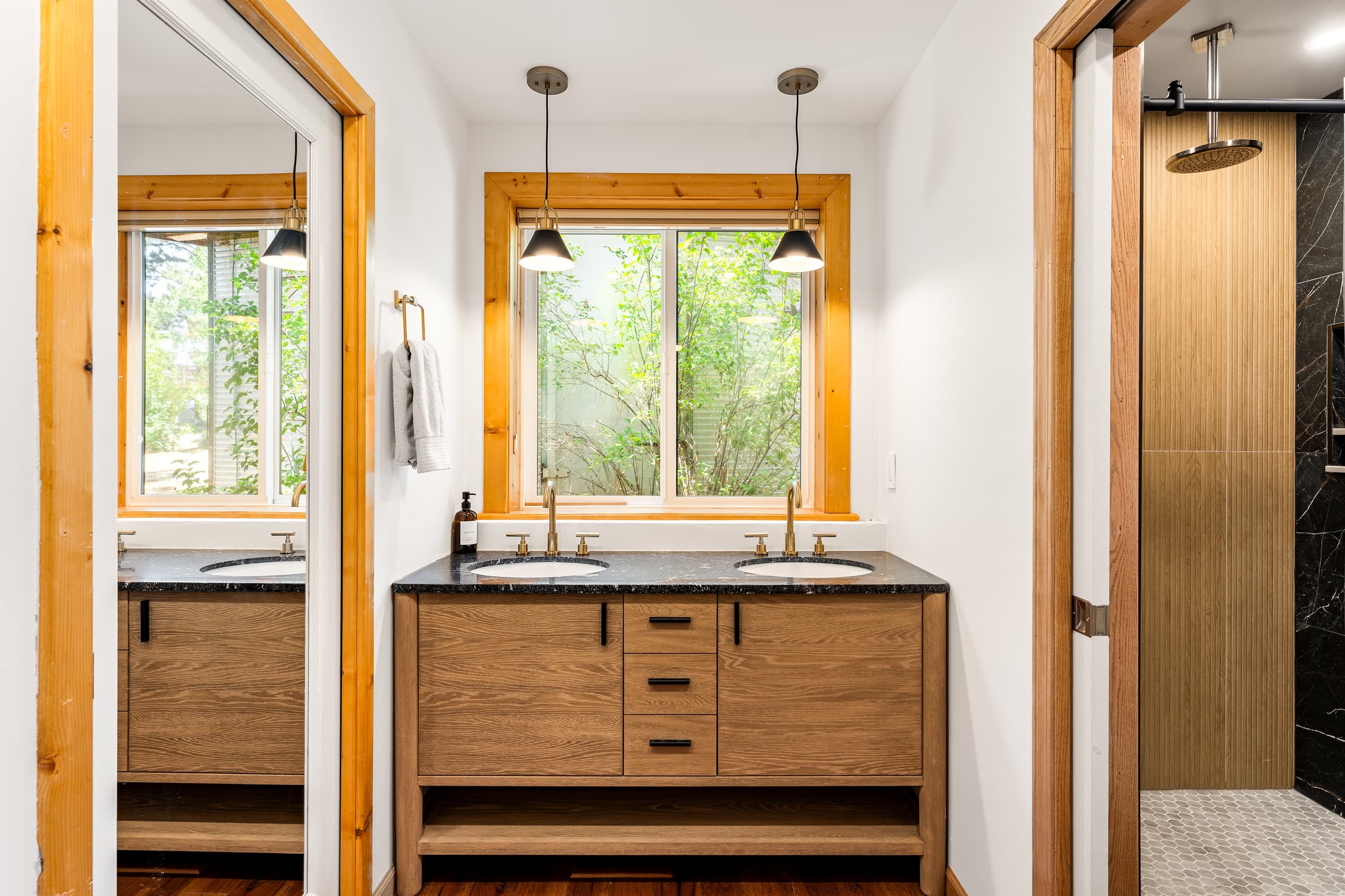 Rest easy in the spacious primary bedroom with a king bed, twin bed with trundle, a 55" Smart TV, and an en-suite bathroom featuring a walk-in shower and dual vanities for your convenience.