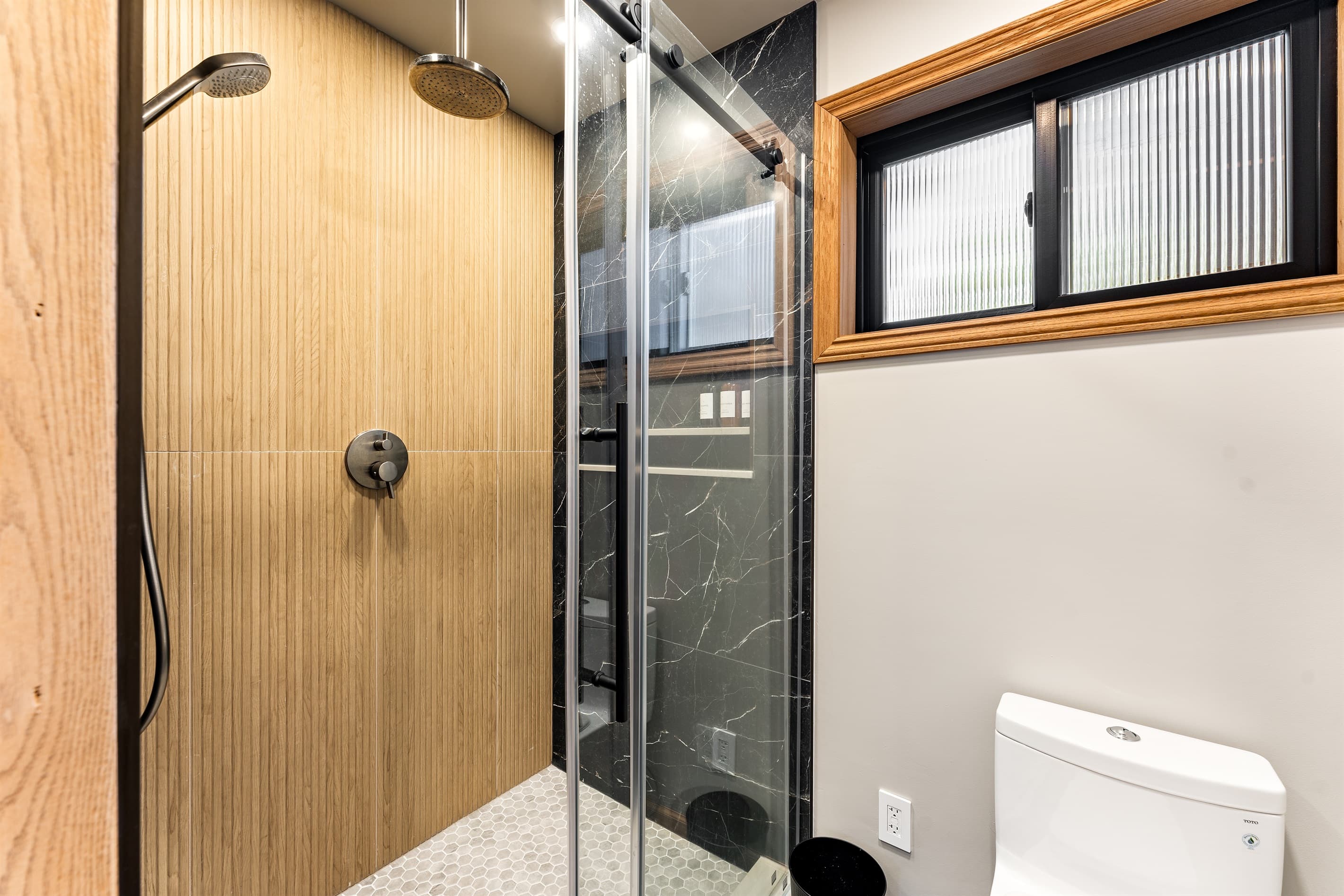 Rest easy in the spacious primary bedroom with a king bed, twin bed with trundle, a 55" Smart TV, and an en-suite bathroom featuring a walk-in shower and dual vanities for your convenience.