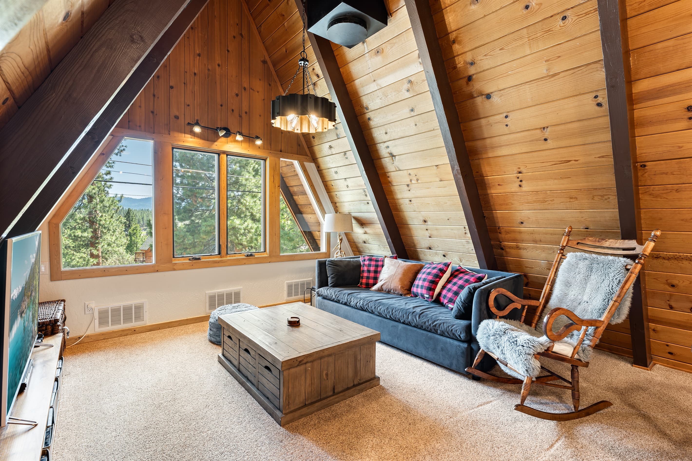 Relax and recharge in the upstairs living room featuring a 55" Smart TV, a cozy card table for game night, direct access to the upper patio, and a sofa bed for additional sleeping space.