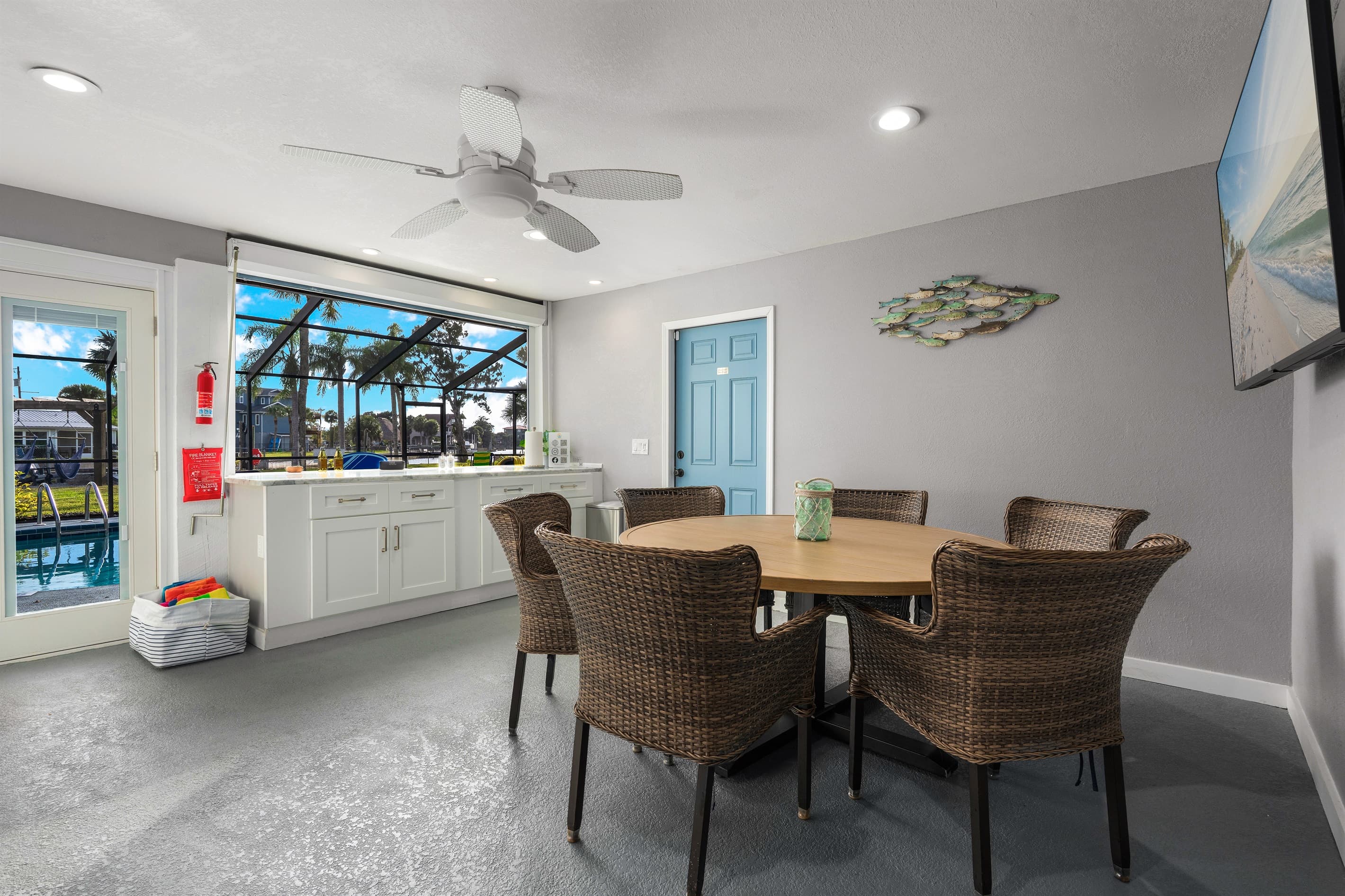 Indoor-outdoor dining with AC,  65" TV, beverage fridge, and  pool access.