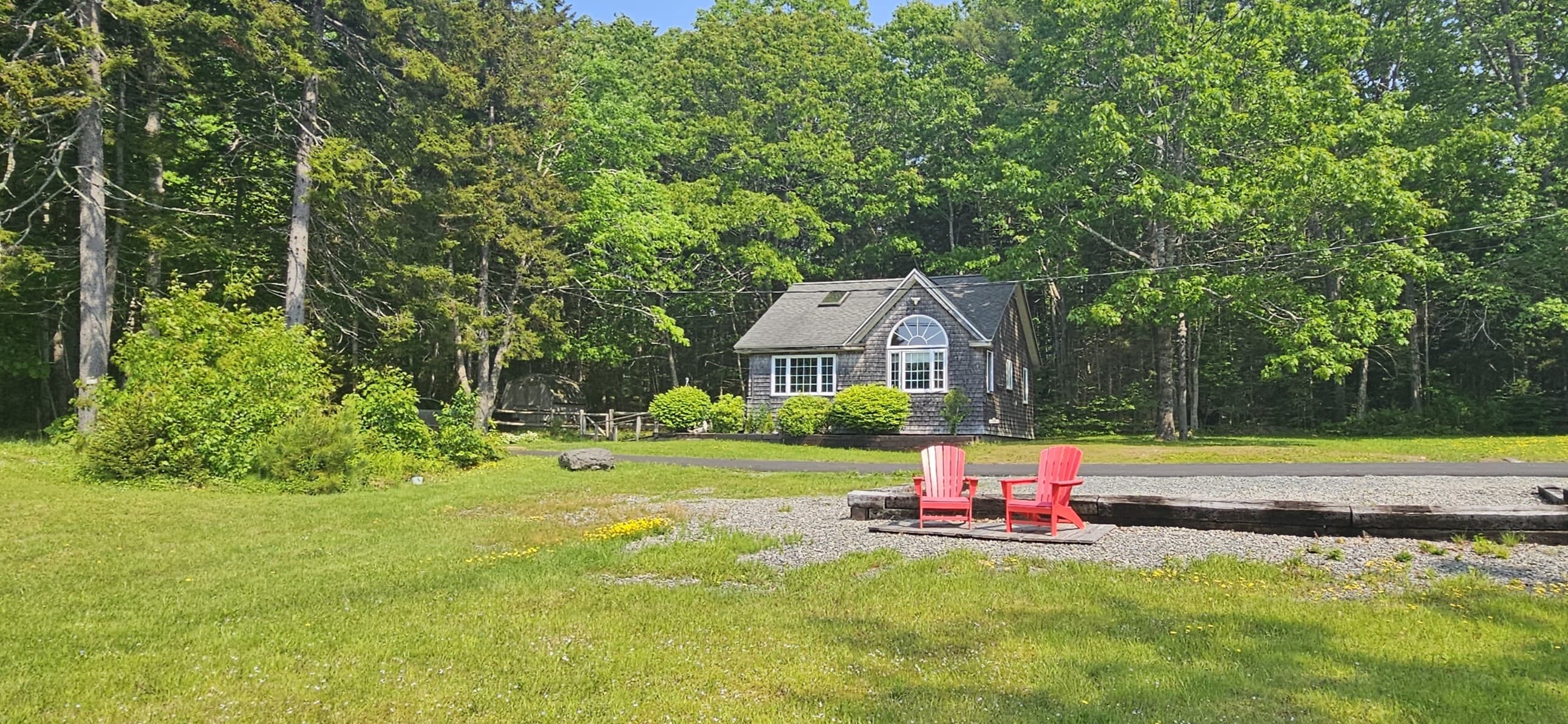 Coastal cottage surrounded by trees and lawn on Maine’s Downeast coast.