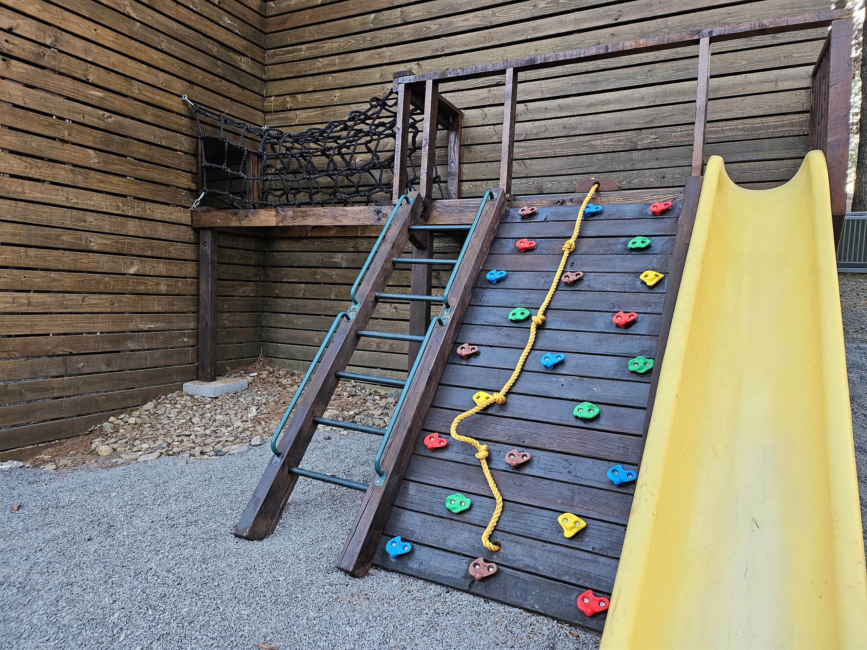 Rock climing wall with Rope net entrance to inside playset structure