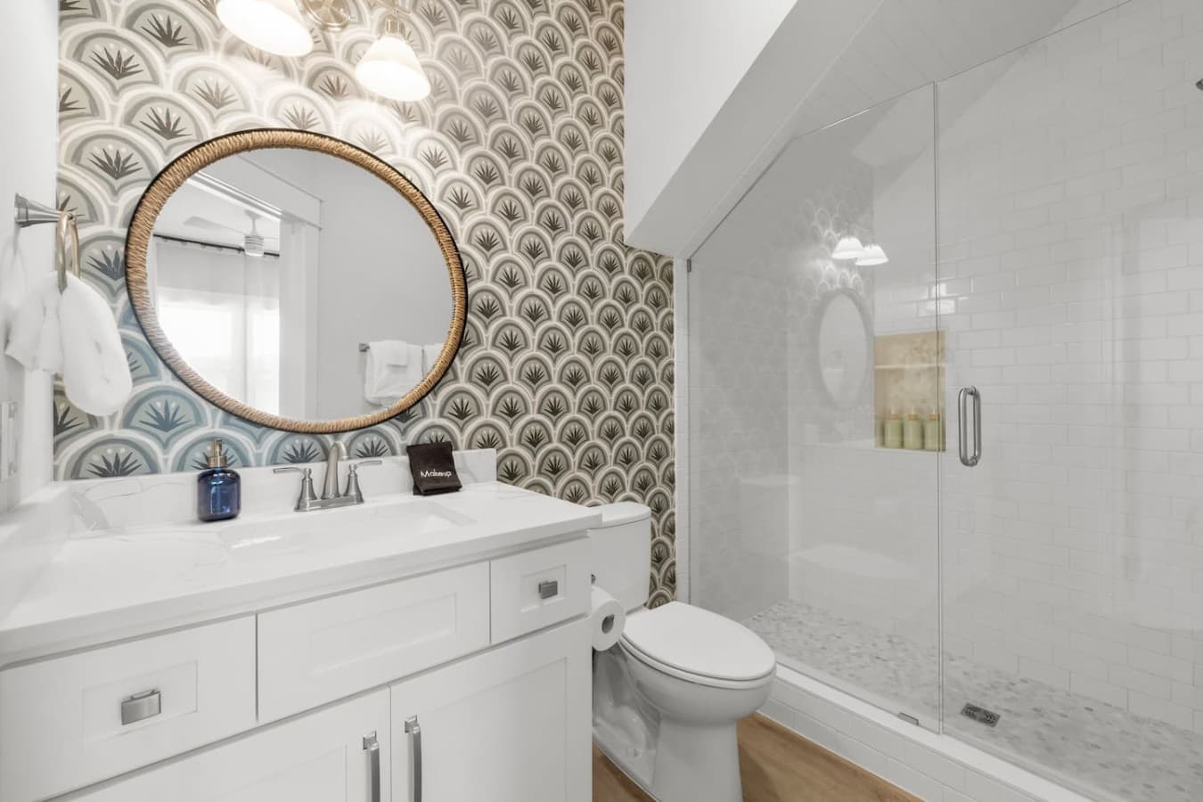 Gorgeous main level king bedroom bathroom with custom wallpaper and a beautiful tile shower