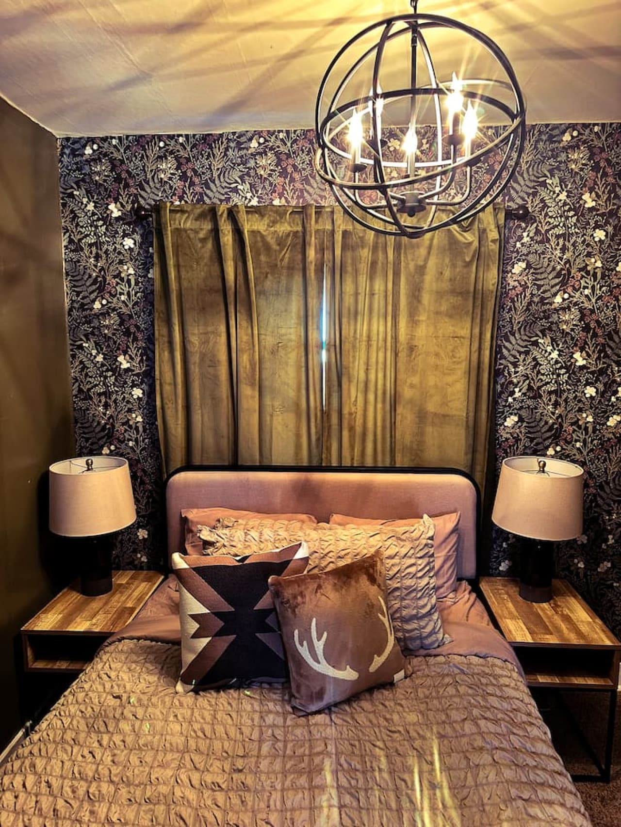 Rustic charm meets cozy comfort. Love the woodsy vibes and the antler pillow in our Bigfoot Hunters Hideaway bedroom.