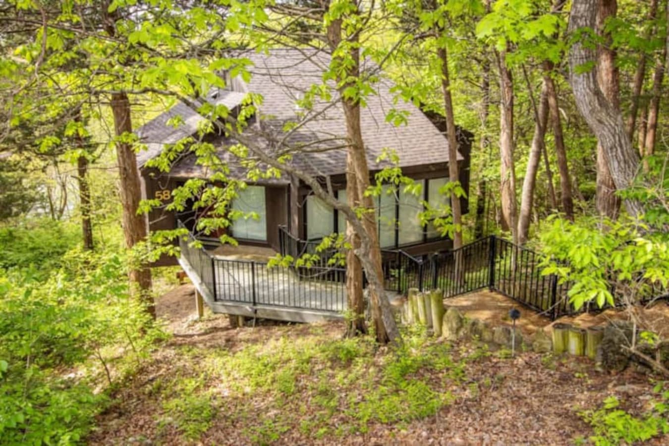This modern elevated home offers a unique "treetop" living experience, blending seamlessly with the surrounding lush natural landscape. Multiple large windows allow for abundant natural light and scenic views, making this a bright and inviting retrea