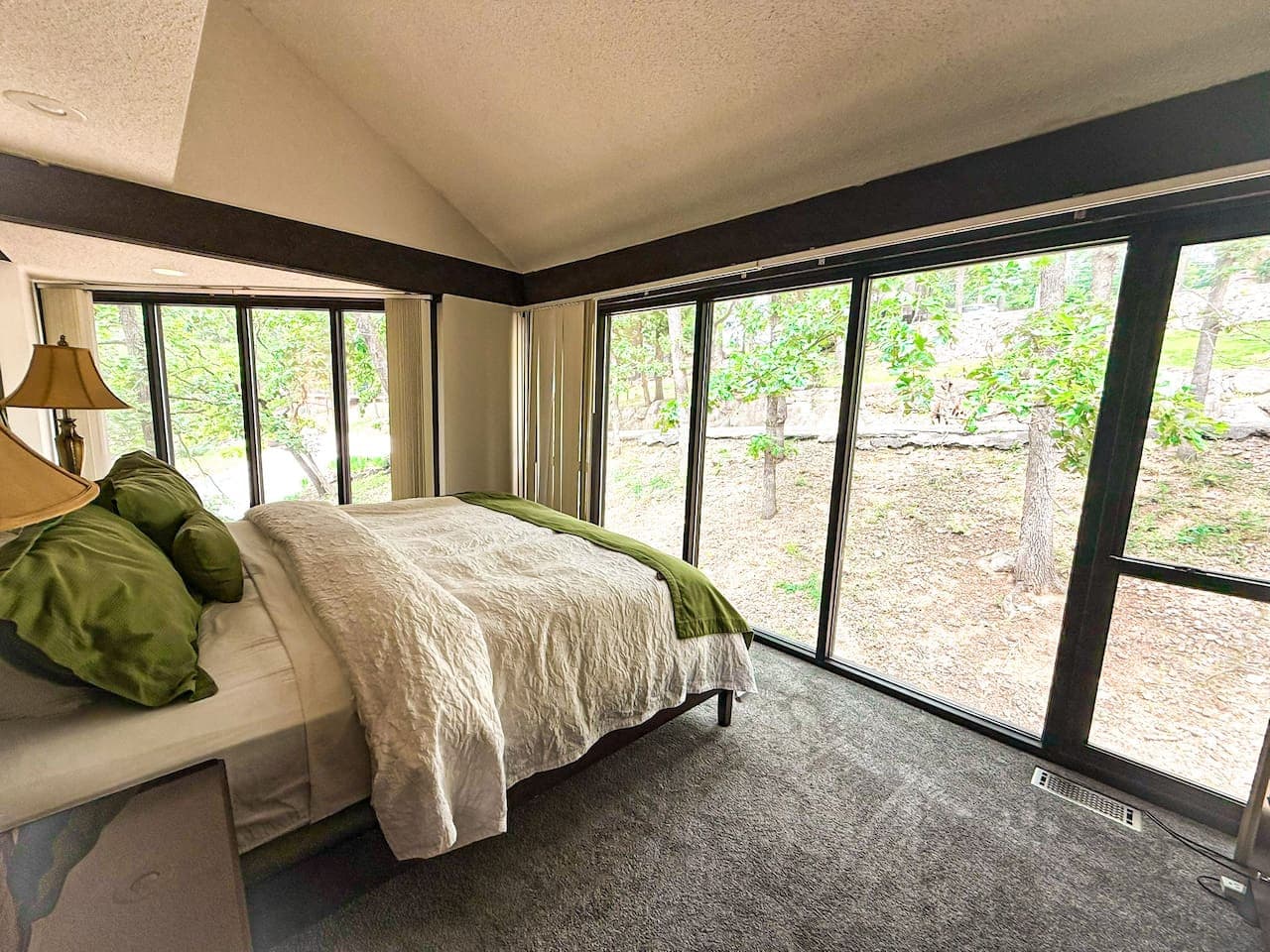 "Wake up to stunning views from this bright and peaceful bedroom! Large windows connect you with the beautiful natural surroundings."