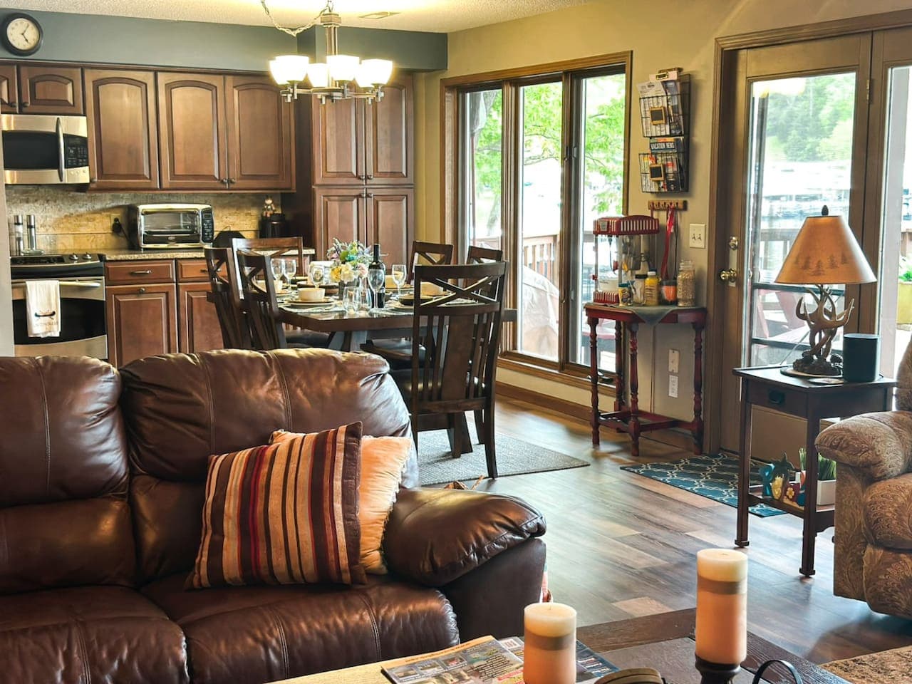 This rustic living room flows effortlessly into the dining area, creating a warm, open space perfect for gatherings. With rich wood tones, cozy textures, and a clear view of the inviting dining room, it’s ideal for both relaxing and entertaining.