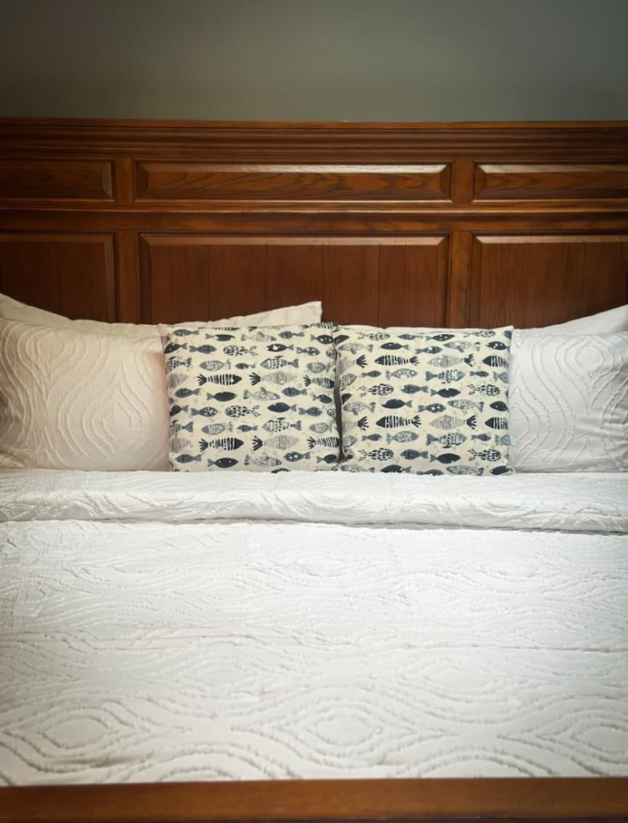 This rustic bedroom is a cozy haven, complete with a mix of warm, earthy pillows that add a touch of charm and comfort to the space. The blend of rustic textures and inviting softness creates the perfect spot to curl up and relax.