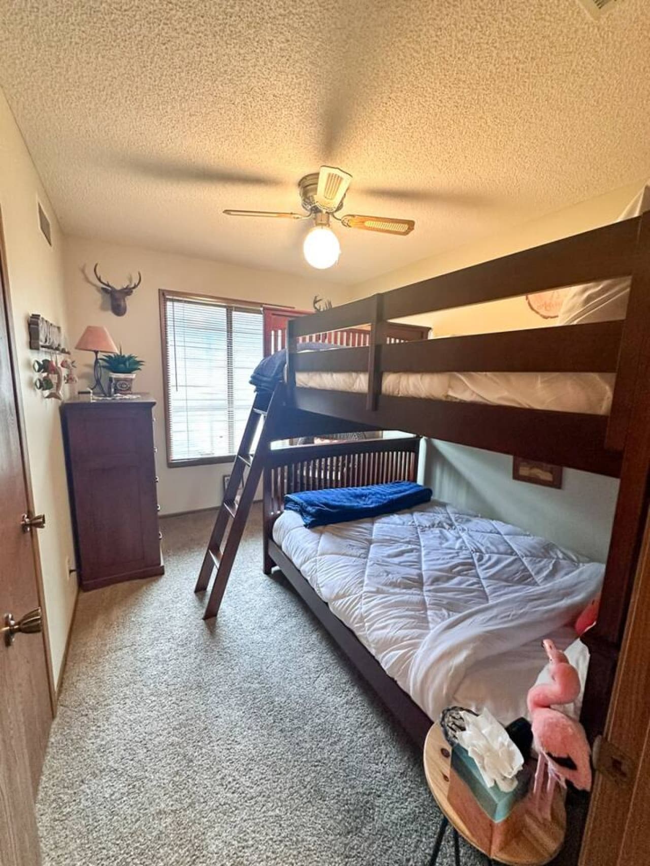 From this angle, the room opens up to reveal the cozy bunk bed tucked neatly against the wall, leaving plenty of space for play. The rustic sock drawer stands out with its weathered wood finish, adding a warm, cabin-like feel to the playful setup.