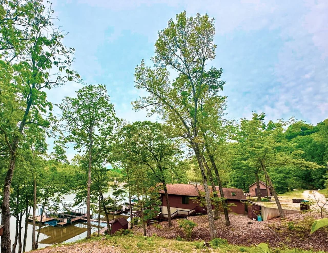 This charming lakeside property is nestled among mature trees, offering a peaceful and private retreat with stunning views of the water. With easy access to private boat docks and multiple cozy cabins, it’s perfect for vacation getaways or full-time