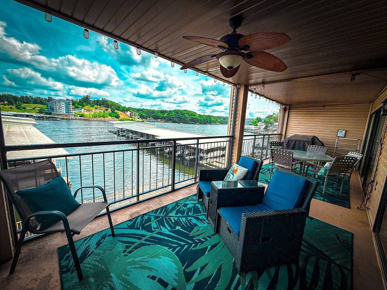 Relax and enjoy the stunning waterfront views from your private, covered balcony, featuring comfortable seating and a tropical rug.