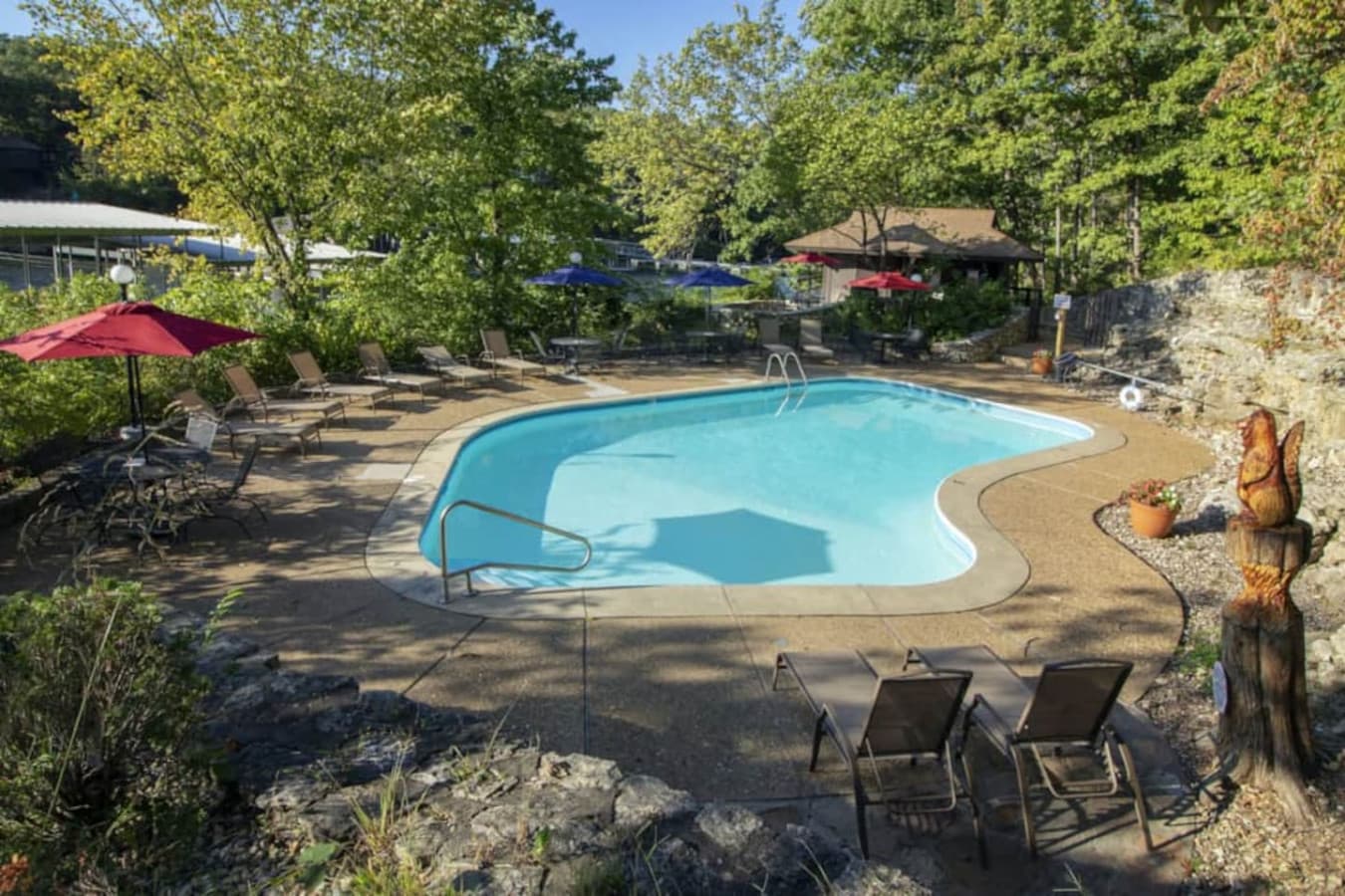 This private, free-form pool is nestled amongst lush trees, offering a refreshing oasis for relaxation and enjoyment. Complete with comfortable lounge chairs and shady umbrellas, it's the perfect spot to unwind after a day of exploring.