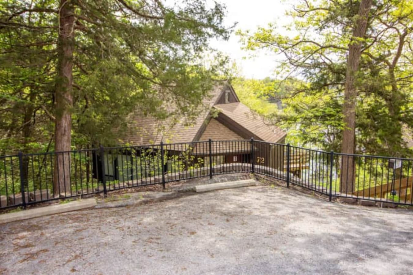 The parking area features an open-space setup made of gravel, providing enough room for a couple of vehicles, ensuring functionality, ease of access, and a straightforward approach to the entrance while maintaining a sense of privacy.