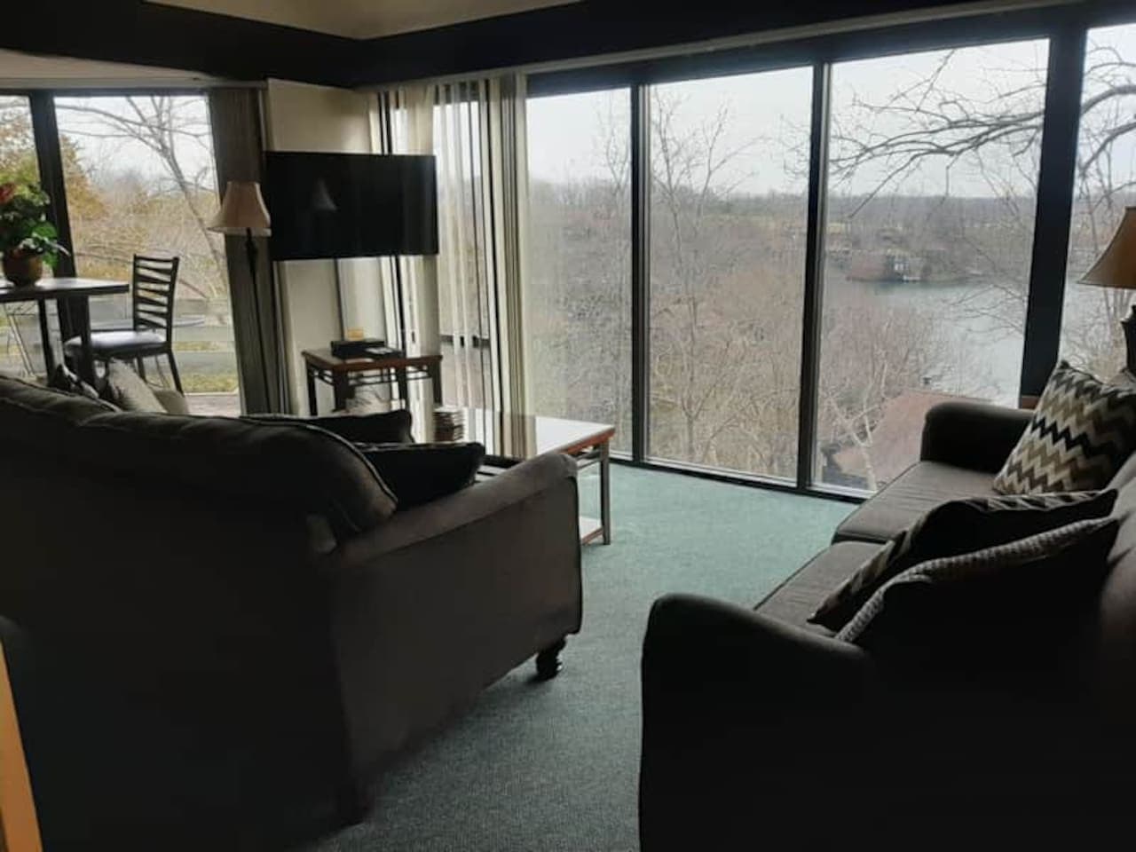"Relax and unwind in this comfortable living room, where large windows offer breathtaking views of the lake – your perfect escape!"