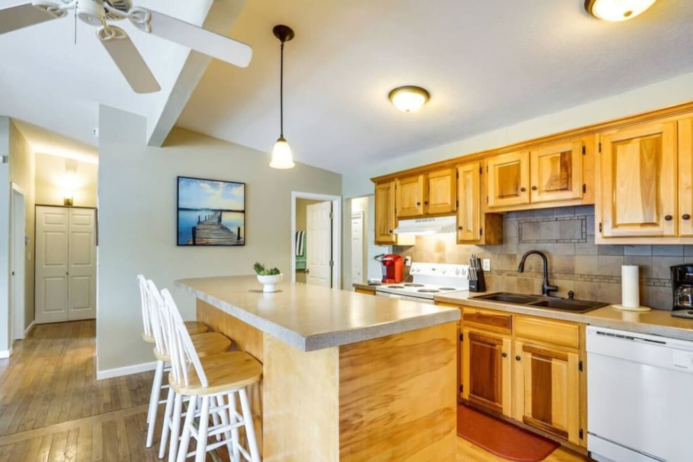A modern kitchen with a wood island, bar seating, and a warm, welcoming vibe, perfect for preparing meals and entertaining.