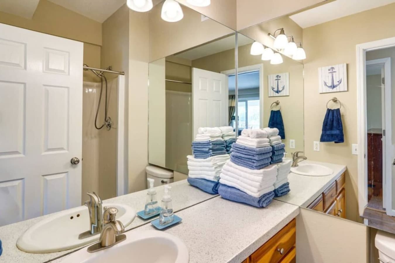 A spacious bathroom featuring a double vanity, ample towels, and thoughtful nautical decor for added charm.