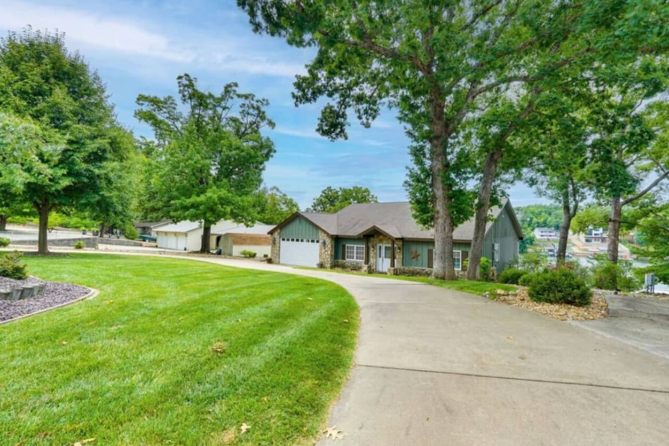 A sweeping driveway surrounded by manicured lawns and tall trees.