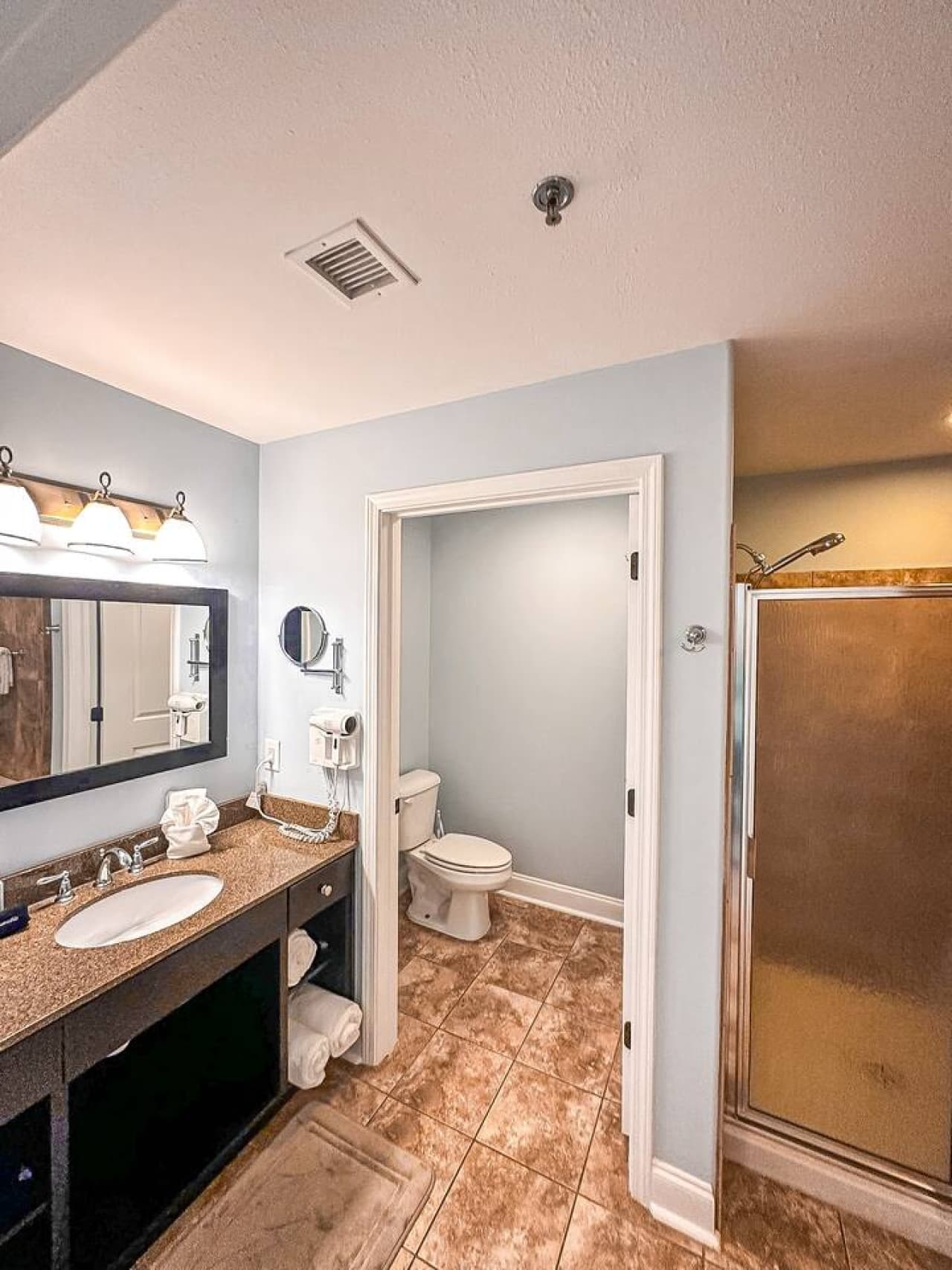 Designed for comfort and convenience, the bathroom includes a spacious shower, private toilet, and granite vanity.
