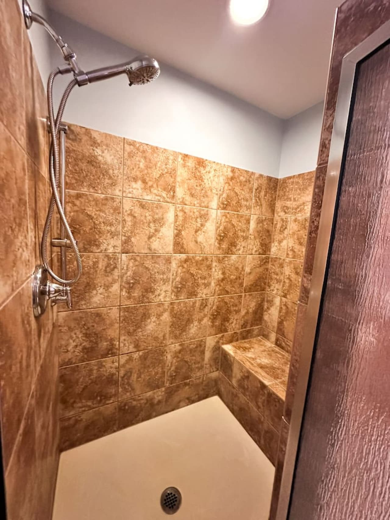 Spacious walk-in shower with a built-in bench and spa-style tile—designed for comfort and relaxation.