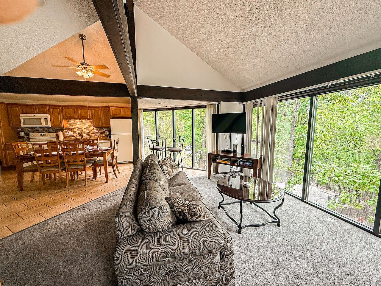 Enjoy a spacious living room with floor-to-ceiling glass windows, offering breathtaking views of nature. Perfect for family gatherings, game nights, and relaxation