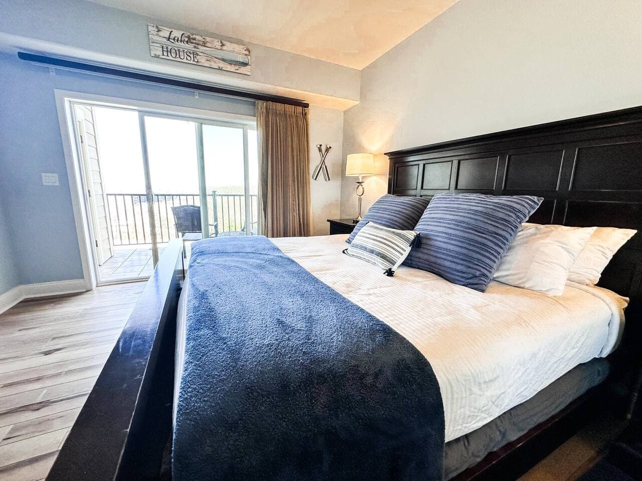 A King master bedroom with direct access to outdoor seating and scenery.
