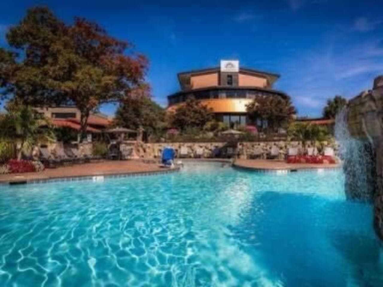 Enjoy resort-style amenities with access to a stunning outdoor pool featuring a cascading waterfall, surrounded by lush landscaping and plenty of lounge seating. Whether you're sunbathing or taking a refreshing dip, this beautifully maintained space